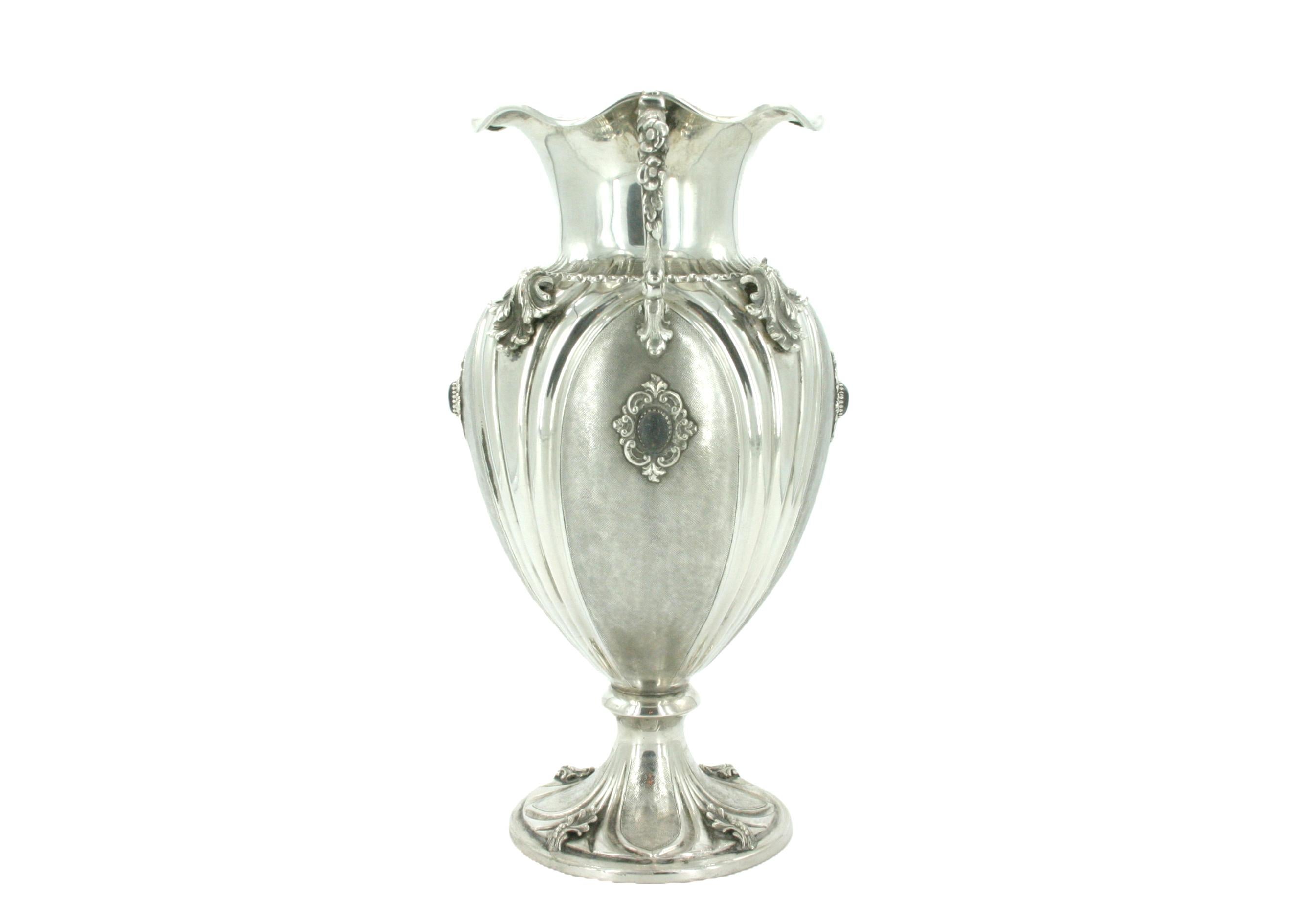 Vase décoratif en argent sterling italien du 19e siècle, avec deux poignées latérales et des détails de conception extérieure. Le vase présente un corps finement ciselé avec des motifs feuillagés appliqués et des pierres semi-précieuses. Le vase est