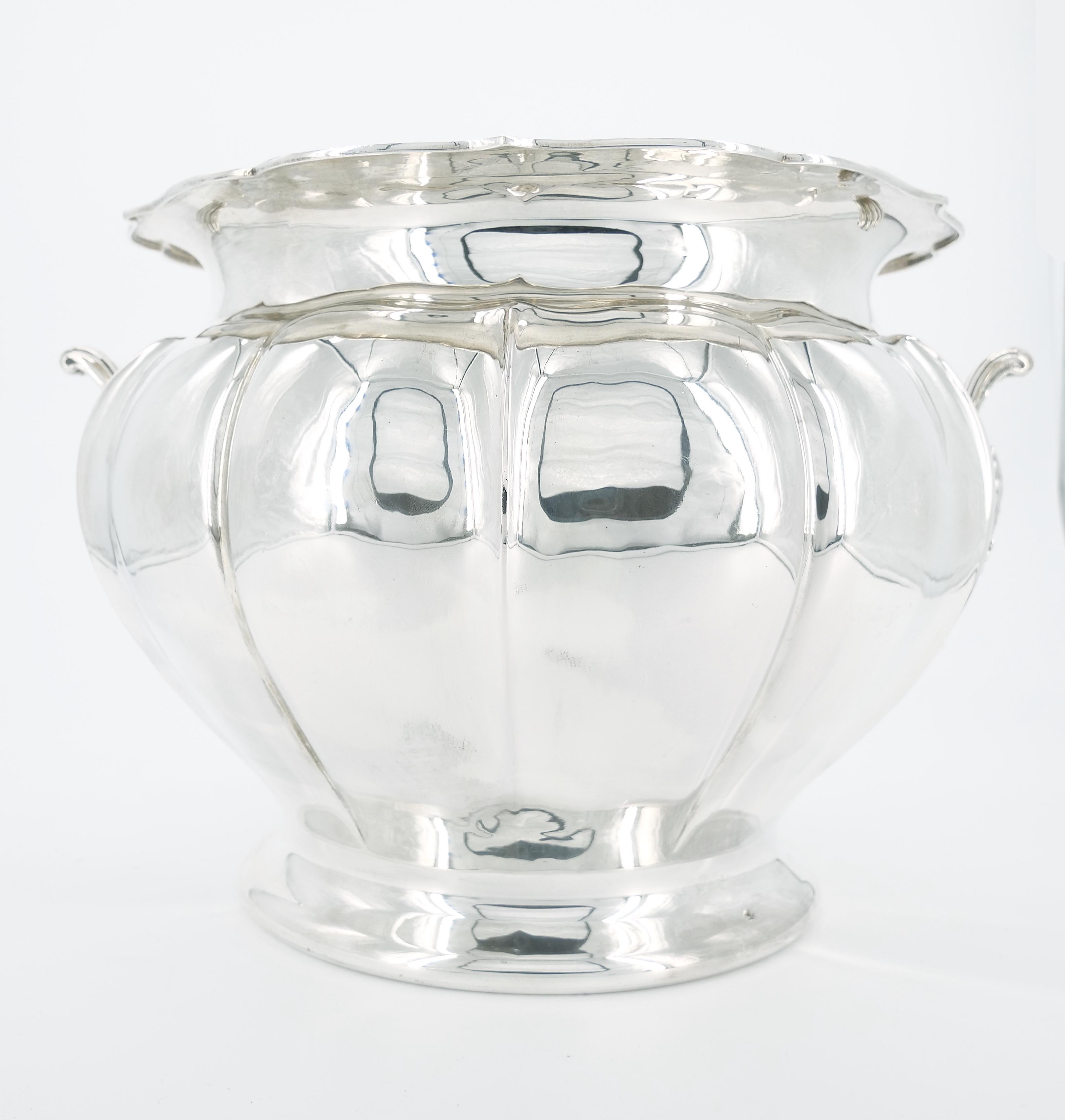 Behold an extraordinary find from the early 19th century – an Italian Sterling Silver and Gold Wash Interior Champagne Cooler, a masterpiece of both function and aesthetic appeal. This exquisite wine cooler or ice bucket showcases a refined exterior
