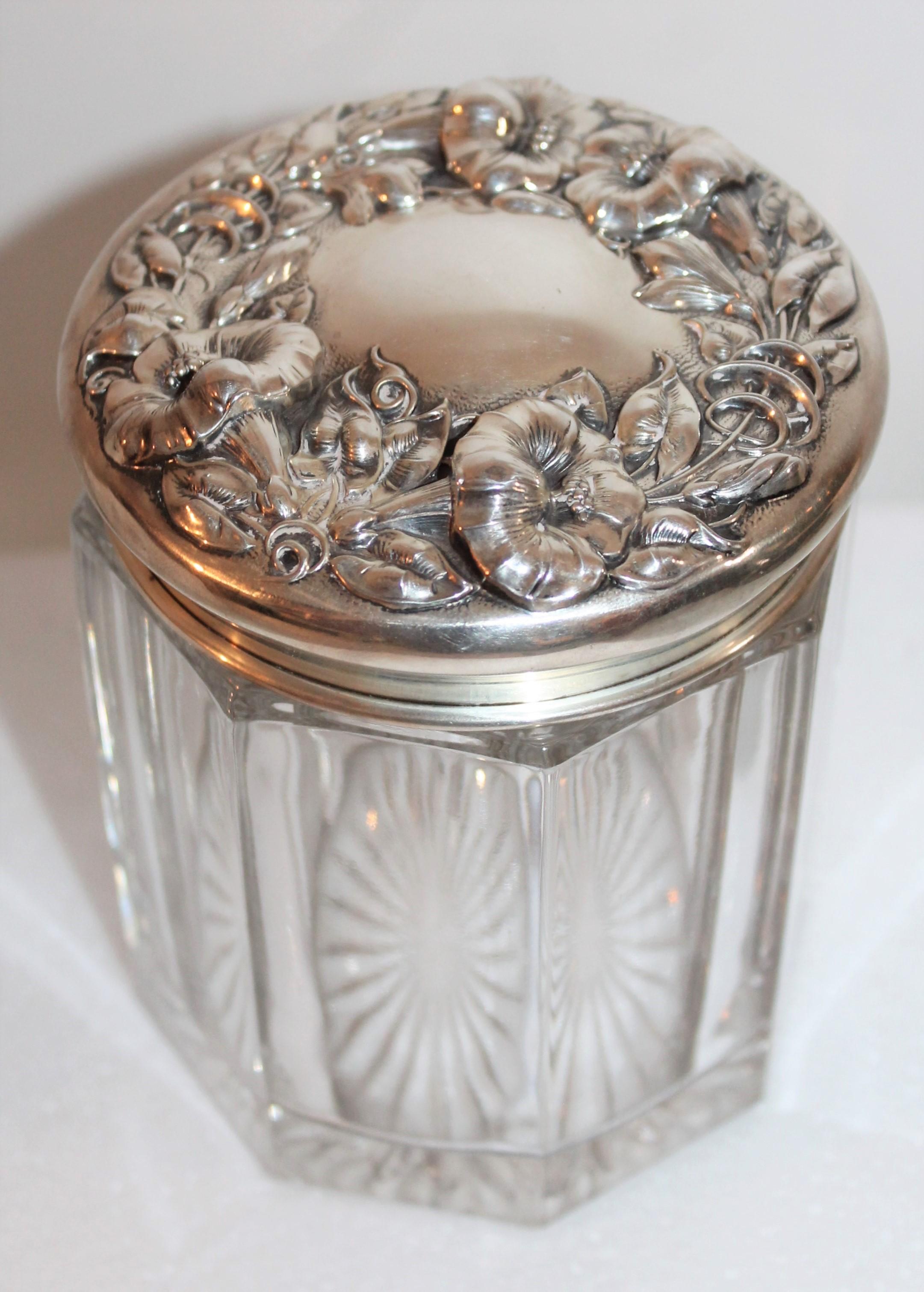 This fine sterling silver lidded jar has a crystal glass base. The condition is pristine. The inside lid has a 24-karat gold wash and is signed sterling. This large jar could be used for many different things as it is tall.