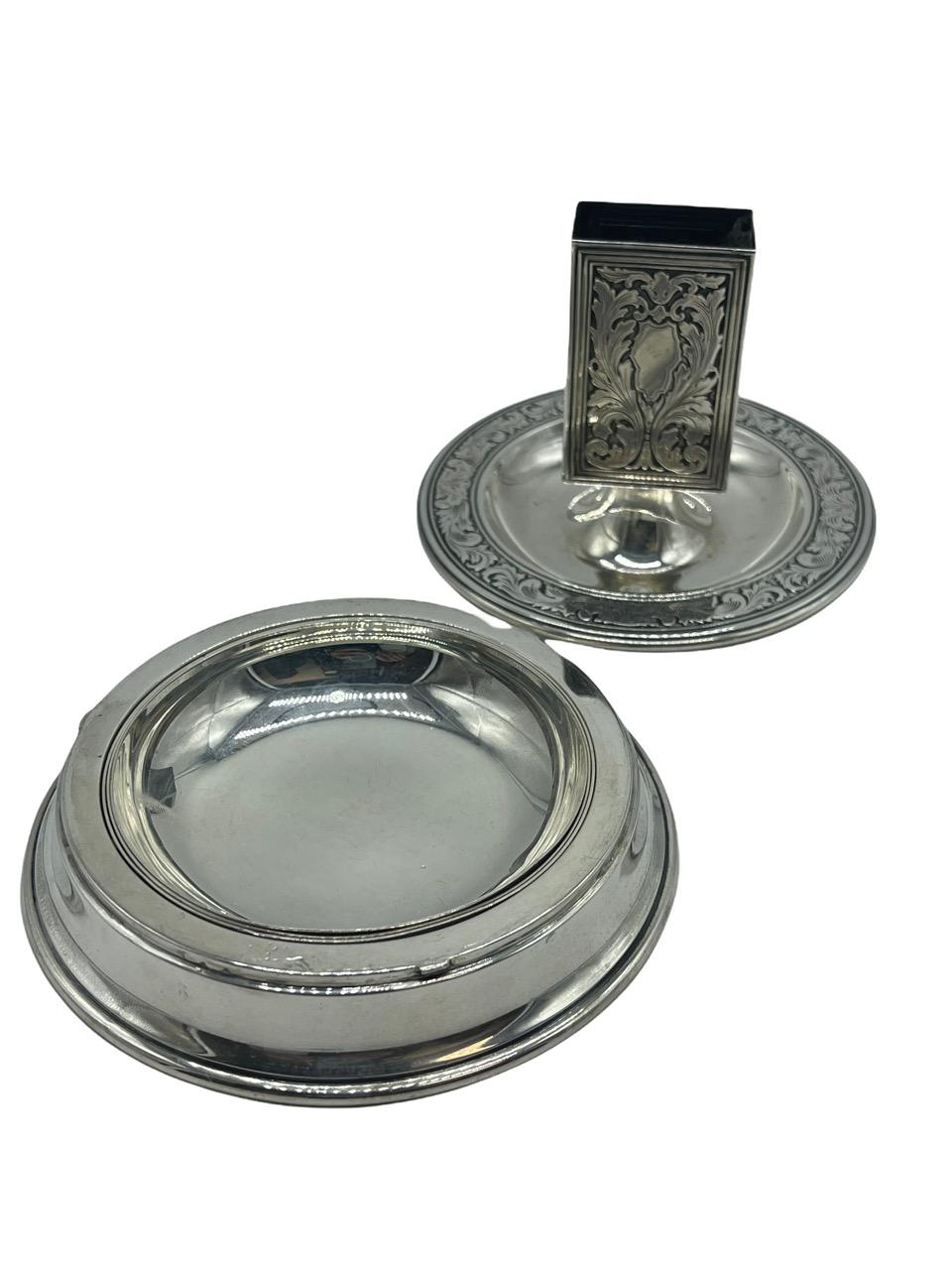 Presenting an exquisite early 19th-century treasure: a Sterling Silver Match Box Holder thoughtfully integrated into an Ashtray Stand by the renowned Tiffany and Co. This remarkable piece of functional art boasts a unique design feature – it can be