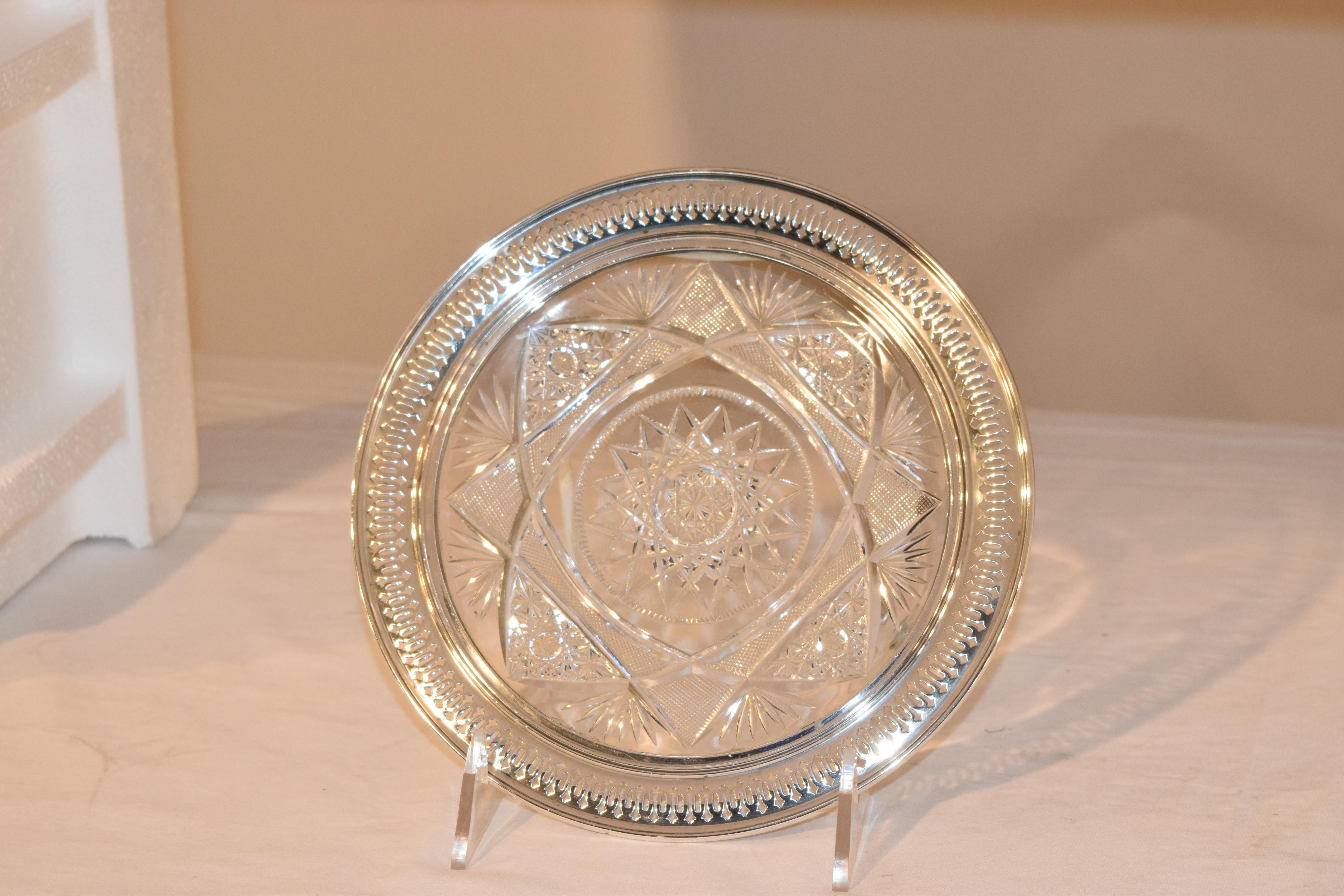 19th century cut glass plate surrounded by a rim of sterling silver, which has a molded edge and piercing. Stamped on the back RW&S, which is R. Wallace and Sons.