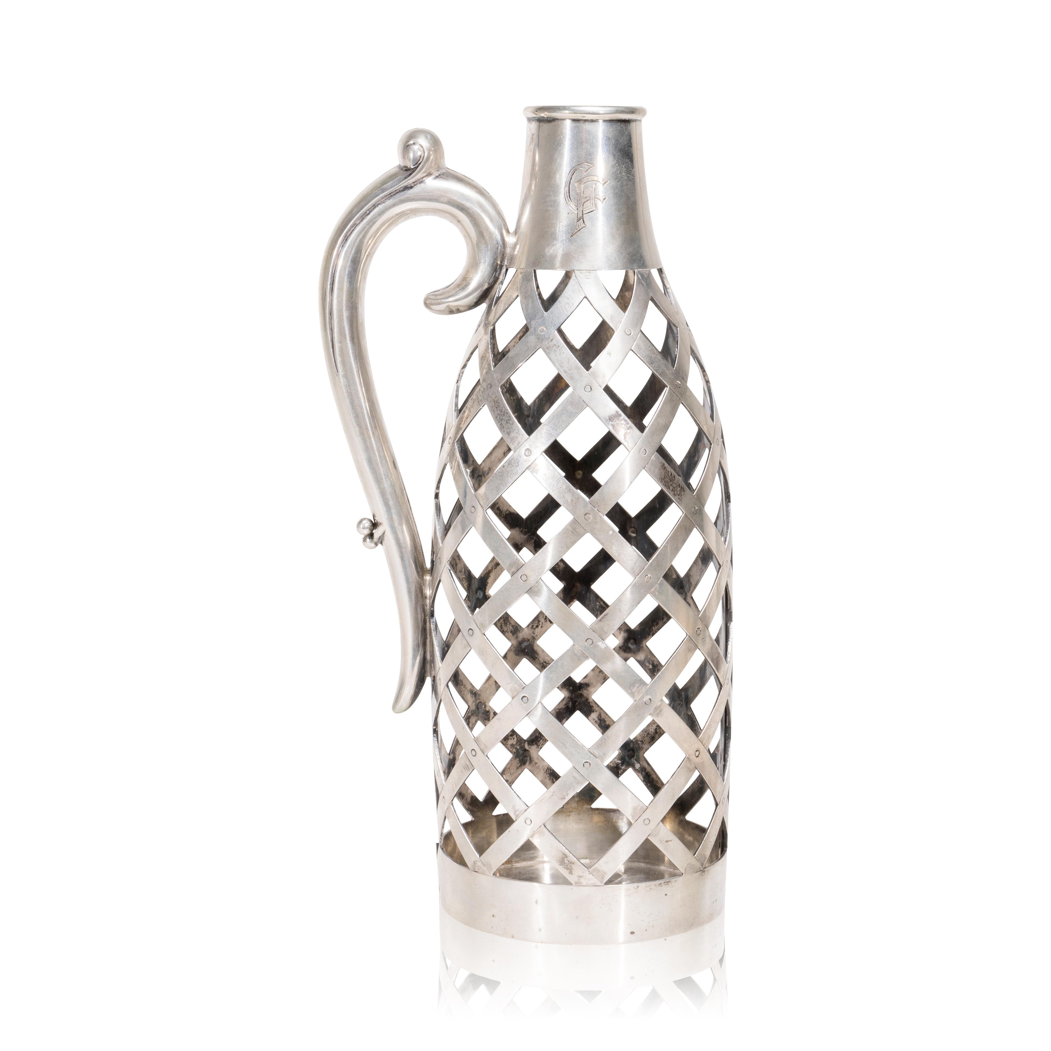 19th Century sterling silver wine bottle holder. German .800 silver wine bottle holder. Berlin, late 19th Century, H. Meyen & Co. Woven body with hinge opposite to handle. Monogrammed. 10 3/4