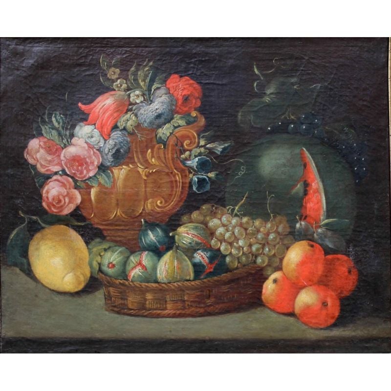 Nineteenth century.

Still life with fruits.

Oil on canvas, 64 x 52 cm.

The still life analyzed presents a mixture of floral and fruit elements arranged in a circular order on a table covered by a green cloth. The left part of the canvas is