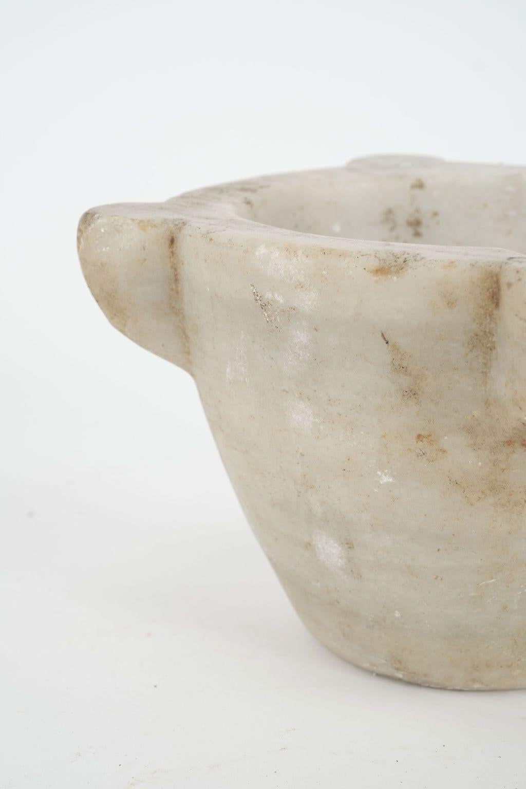 19th century stone mortar from France. Hand-carved alabaster mortar in a conical shape with four handles. One handle notched with a channel for pouring. Beautiful as a sculptural accent piece or decorative bowl. Seven stone mortars of varying shapes