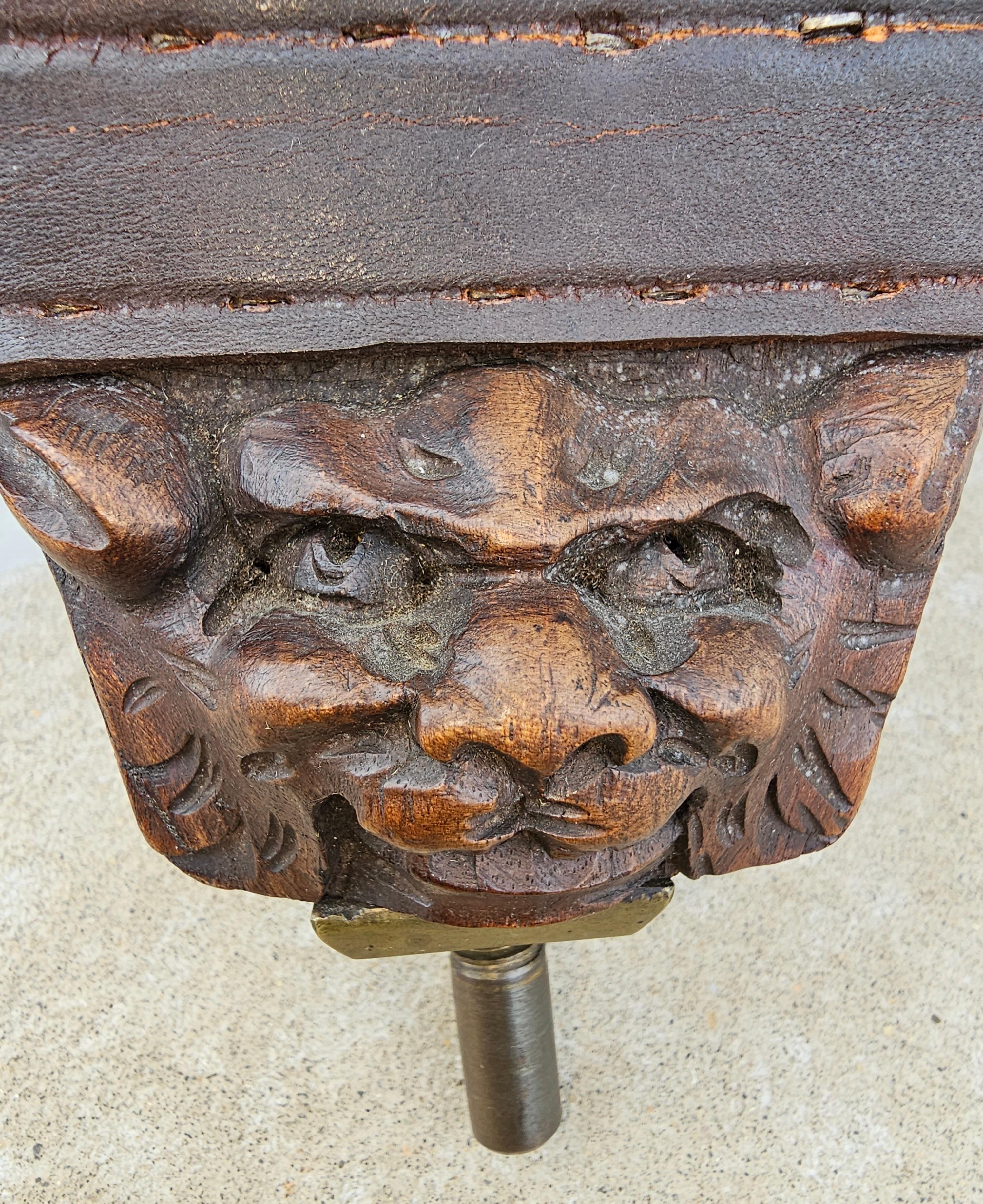A 19th century Intricately carved Italian fire bellows decorated with winged gri ns, roaring lion head, human figure, three cherubs and coat of arms on the verso. Lined with a leather to expand the bellows to fan a fire. Studded with brass pointed