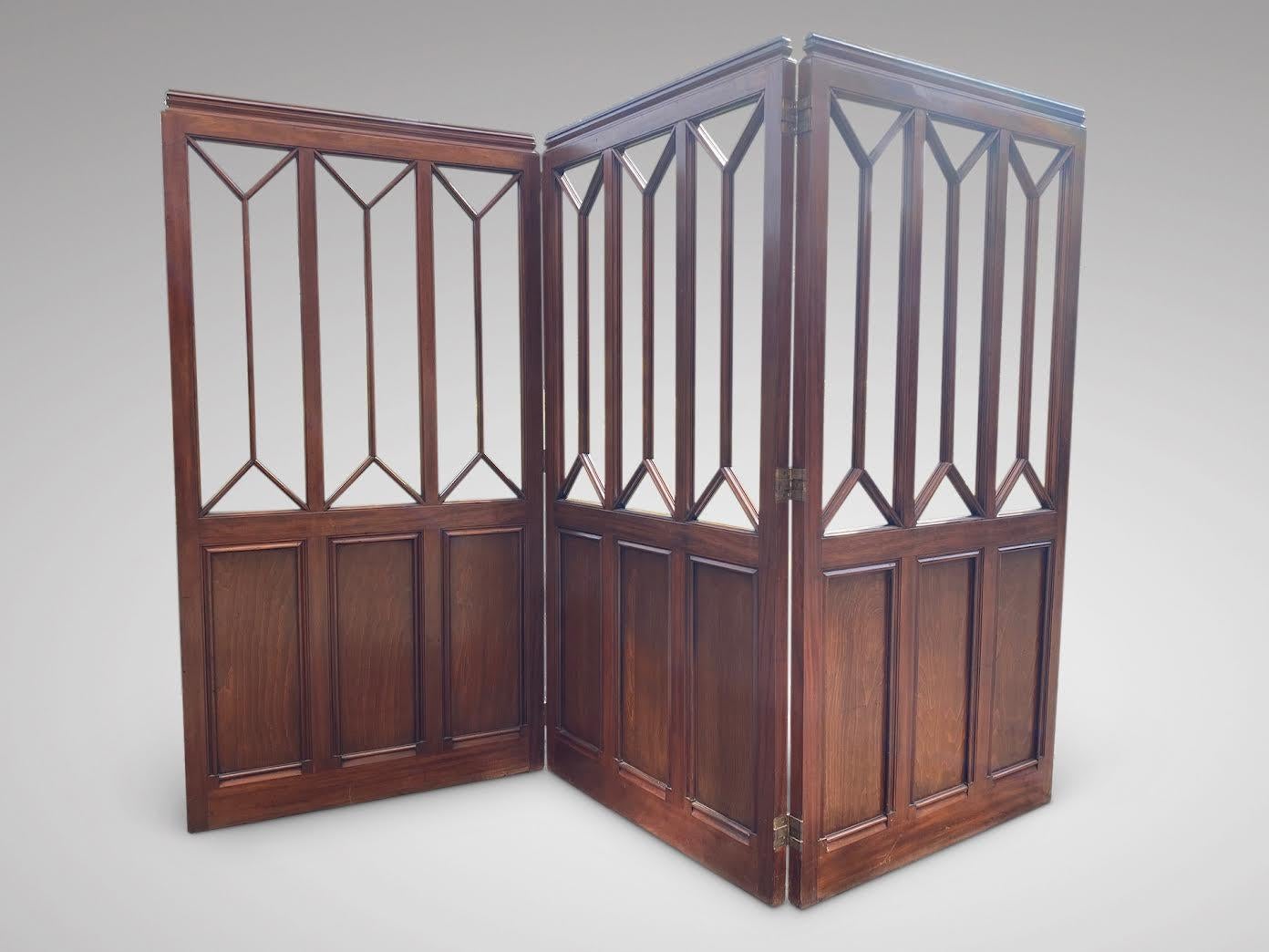 A stunning quality 19th century mahogany folding three panel dressing screen or room divider, featuring lovely mahogany panels below and astragal openings to the top part. Three mahogany wooden panels on triple swing hinges. The triple swing hinges