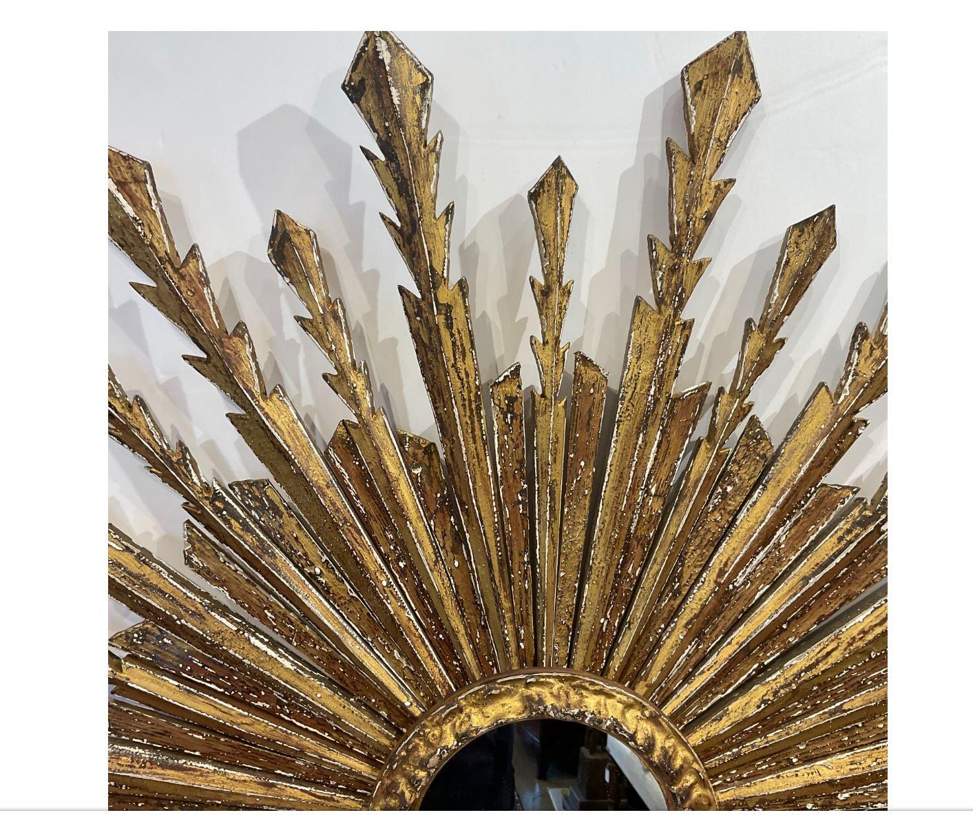 Beautiful Italian 19th century vintage sunburst mirror! This is a stunning piece with wooden rays that are hand carved and gilded in gold with beautiful detail on the edges. This would make a wonderful showstopping addition to any home!