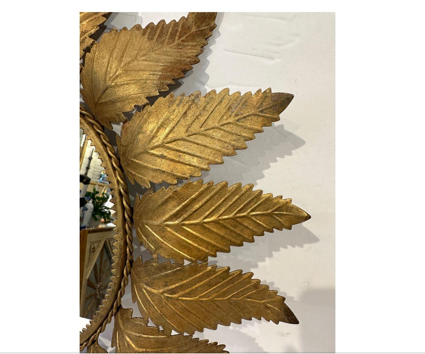 This is a beautiful 19th century Sunburst mirror! The toleware leaves have lovely intricate detail. There is a twisted gold rope border around the circumference of the mirror combined with a symmetrical triangle border as well. The delicate floral