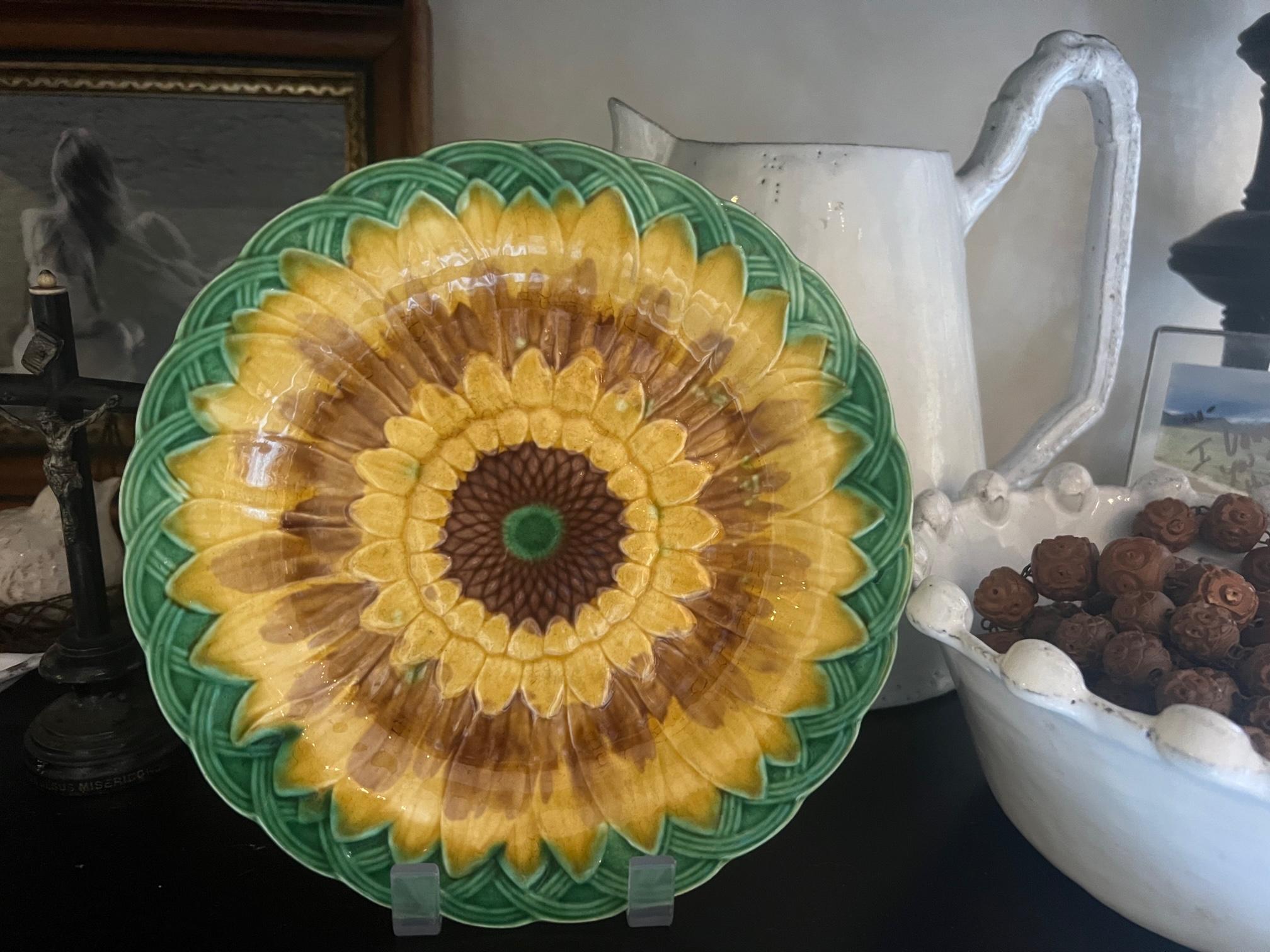 Antique majolica plate made in 1870 by Wedgwood in England. The plate features a vibrant yellow sunflower in a green basket. The Wedgwood hallmark is on the back.