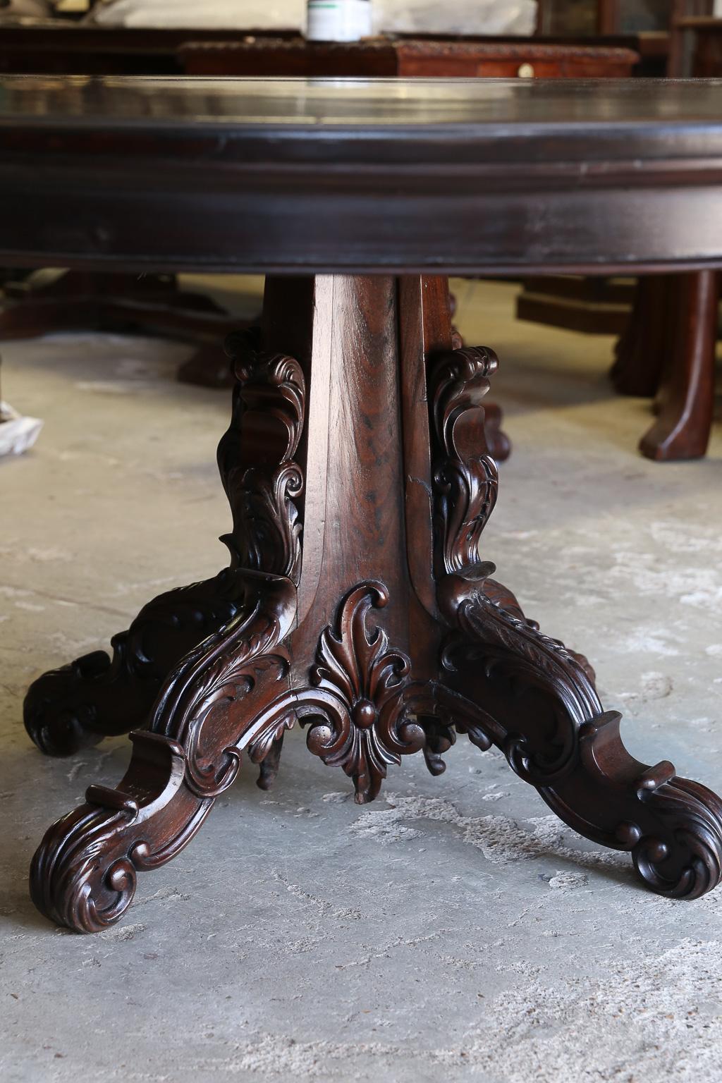 This table once adorned the summer residence of a Governor of a southern province in India. See the immaculate precise carvings of the four feet and the central columnar support. The round top of the table is made up of only two pieces of wood. This