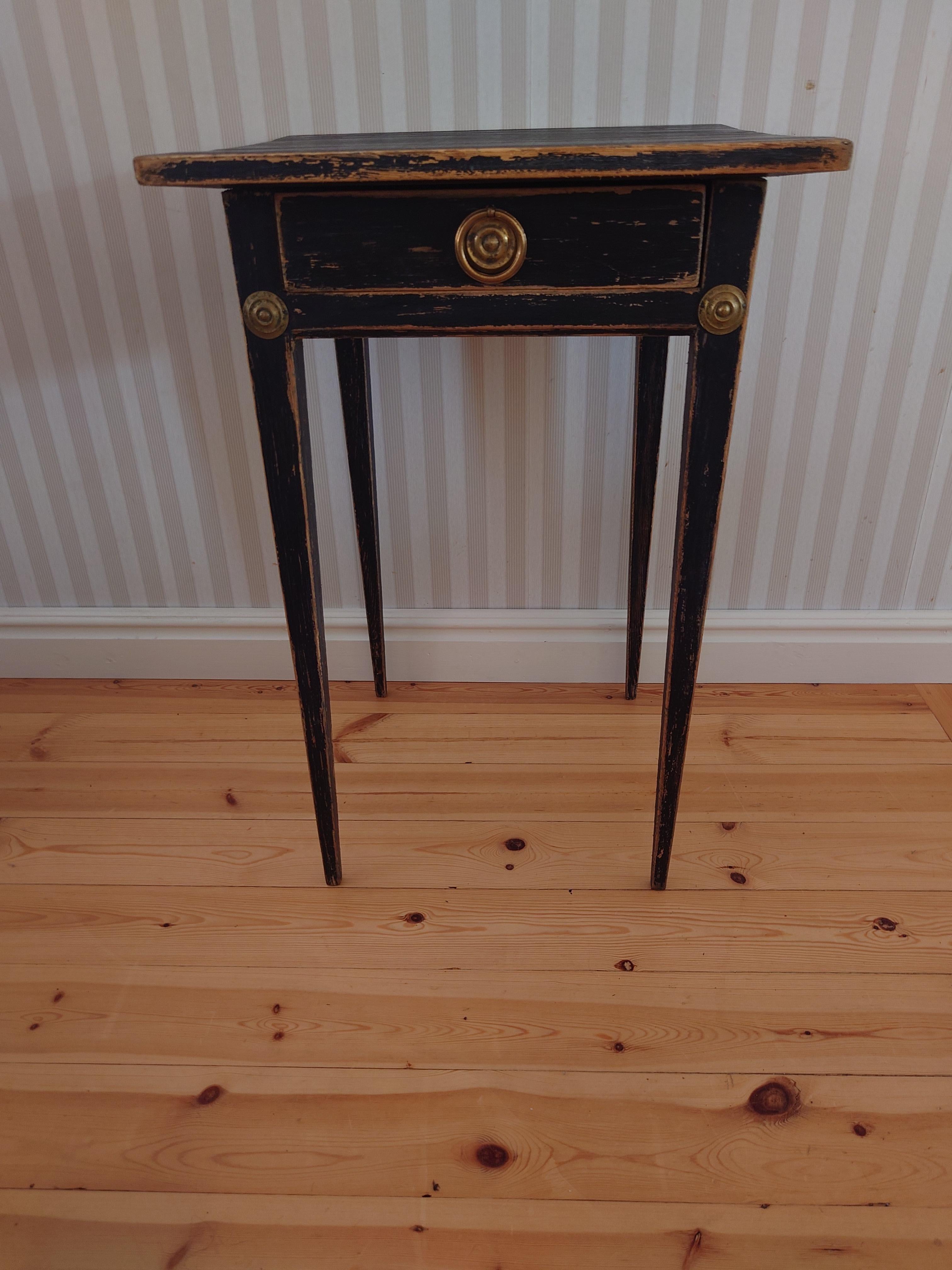 Black  Gustavian side table  from the early 19th century, 1820 to 1840. The table is a classic country house furniture from Sweden and made in pine. The black paint is later and distressed, making some of the pine underneath shine trough. It has the