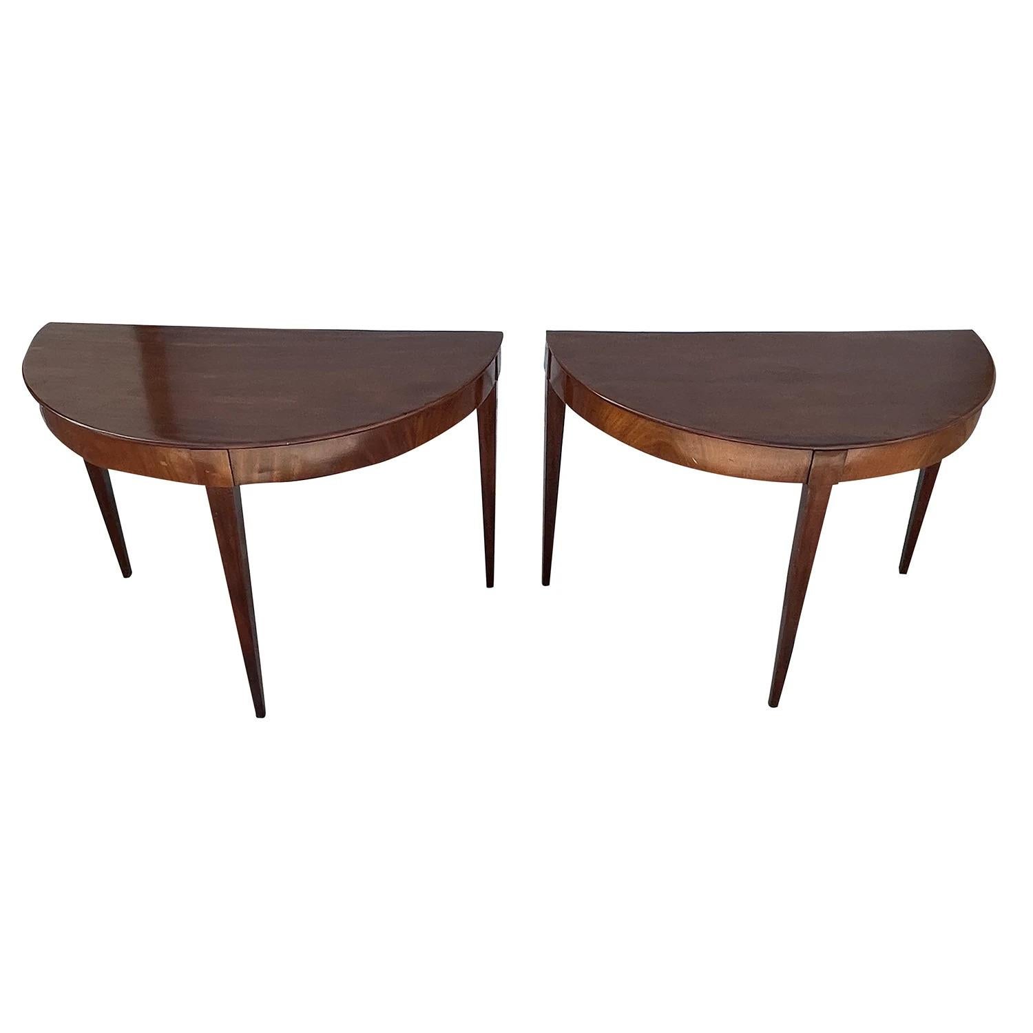 A dark-brown, antique Swedish Gustavian pair of Demi-lune, side tables made of hand crafted veneered Mahogany, in good condition. The half round, moon shaped polished console tables were original dining tables. Wear consistent with age and use.