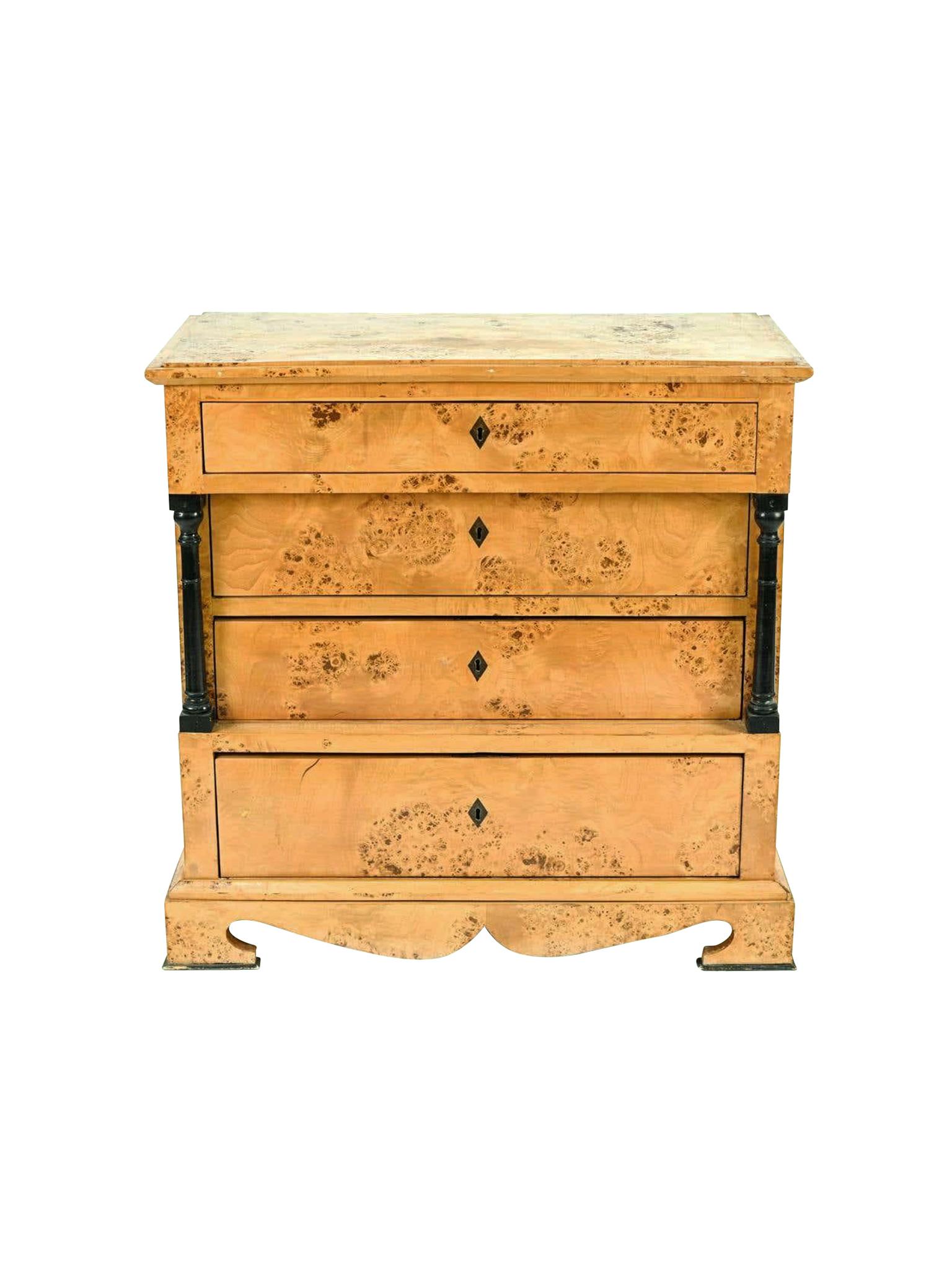 Antique Biedermeier chest of drawers, handcrafted in Sweden in the 19th Century. It's comprised of birch burlwood with ebonized columns and feet trims. The chest is constructed with 4 full-length drawers.

Dimensions:
35.75 in. width
18.75 in.