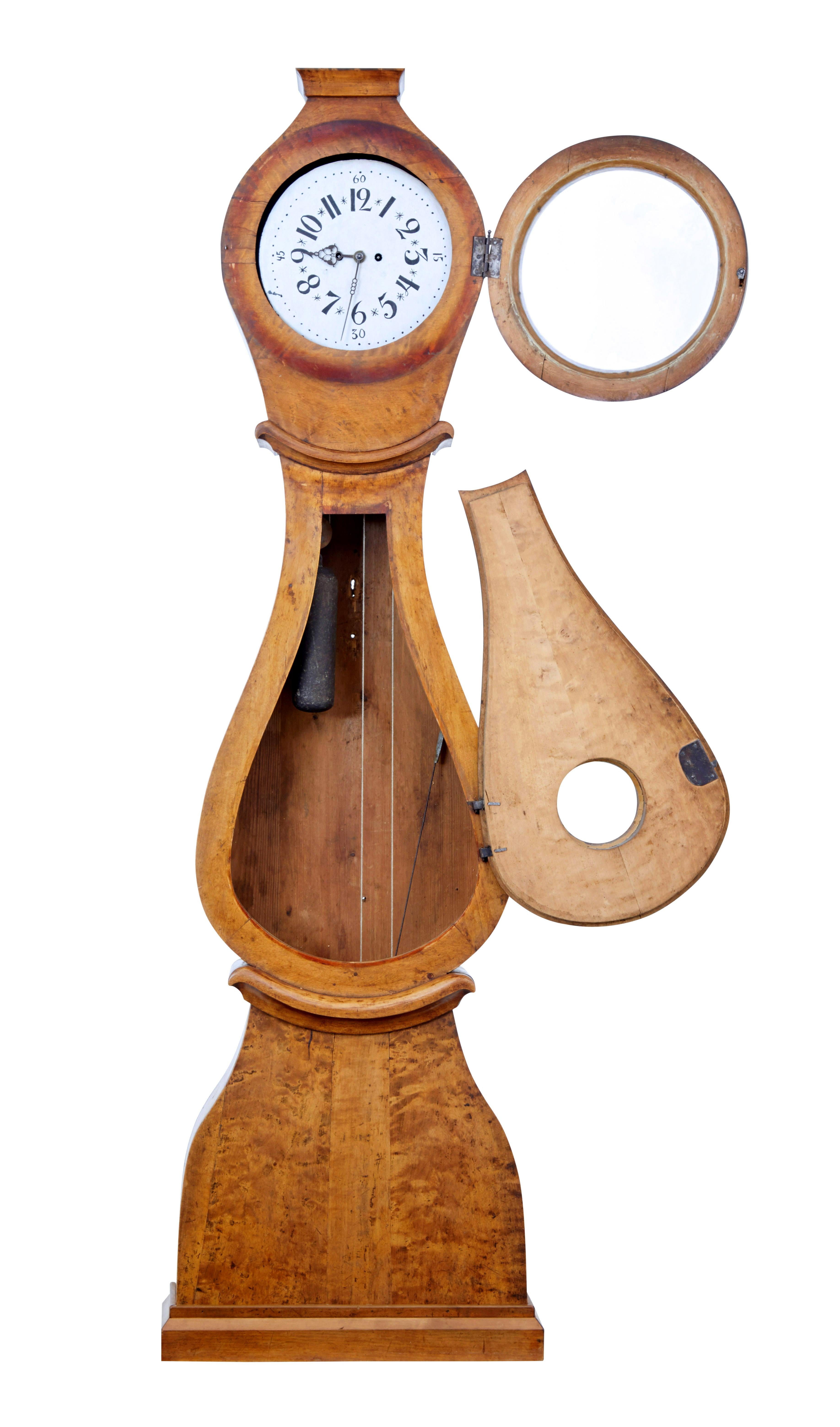 19th century Swedish mora long case clock, circa 1850.

Presented in its original birch finish which has taken on a good patina. Naive hand painted enamel clock face with expected minor losses and rubbing.

Removable round hood and hinged door.