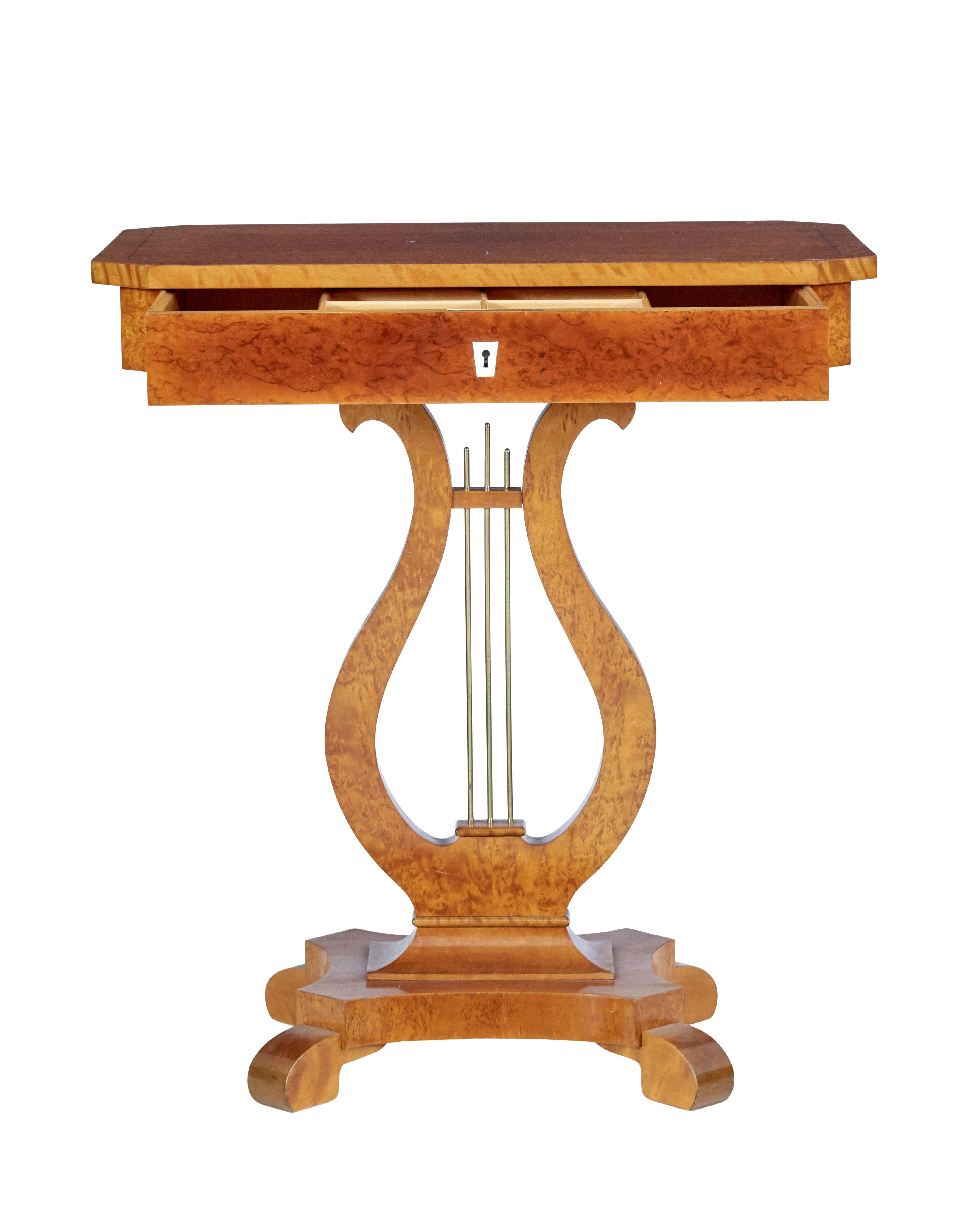 19th century Swedish birch lyre form occasional table, circa 1890.

Rectangular top with canted corners, veneered in burr birch with salt and pepper stringing detail. Single drawer below which is fitted with compartments. Stands on a lyre form