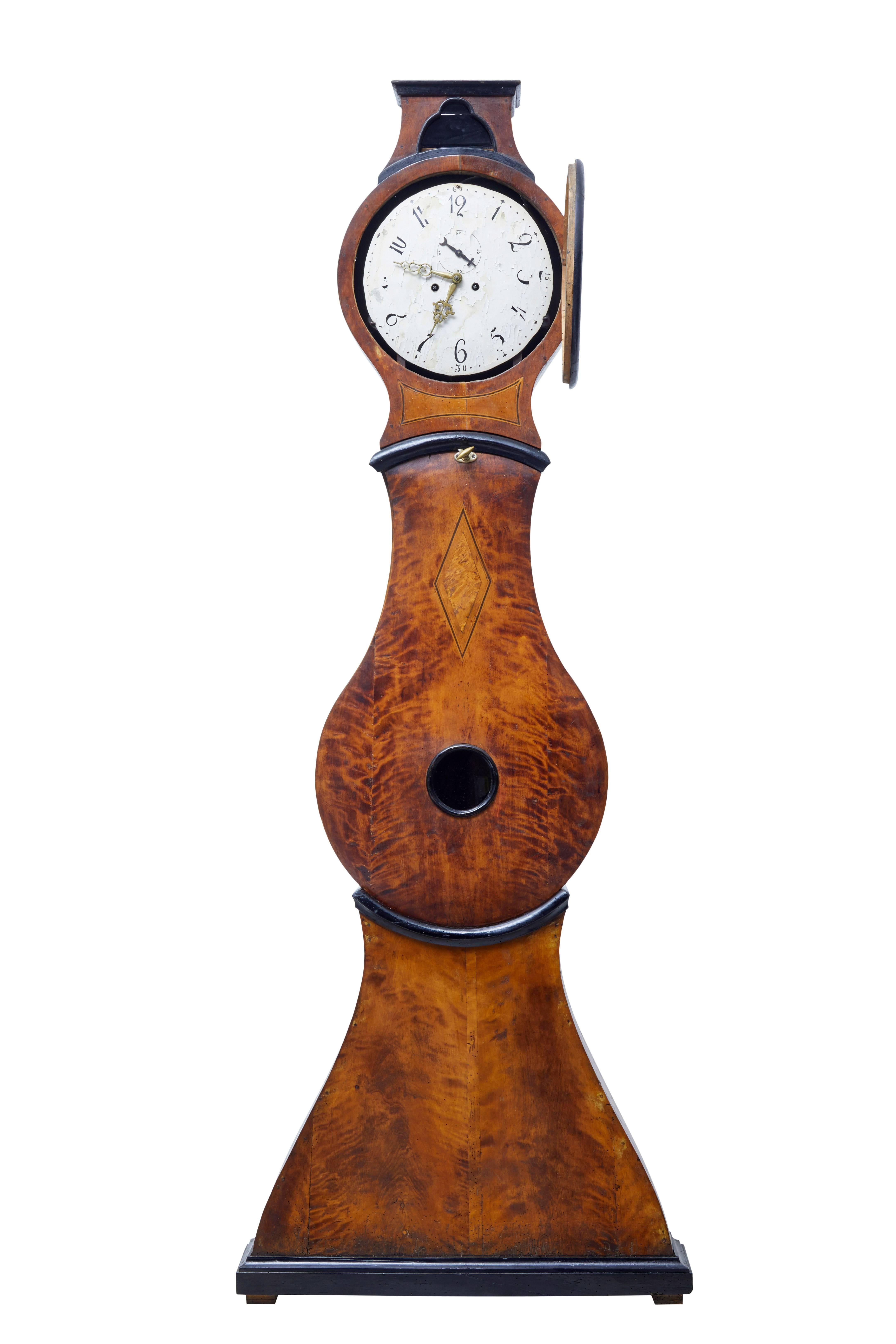 Elegant shaped Swedish Mora clock, circa 1840.

Beautifully made in burr birch and contrasting ebonized elements, with inlay and stringing to the body and hood.

Original face and movement, extensive losses to the enamel on the face but there is