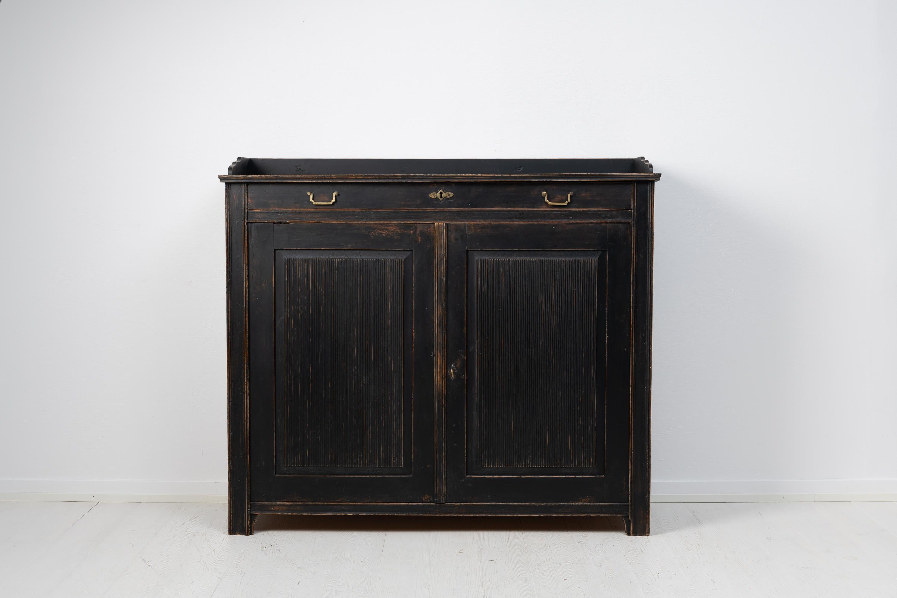 Gustavian style black sideboard from Sweden made during the early 19th century, around 1820. The sideboard is in gustavian style with later black paint which has become distressed. The interior of the sideboard is wood bare with a wide slim drawer