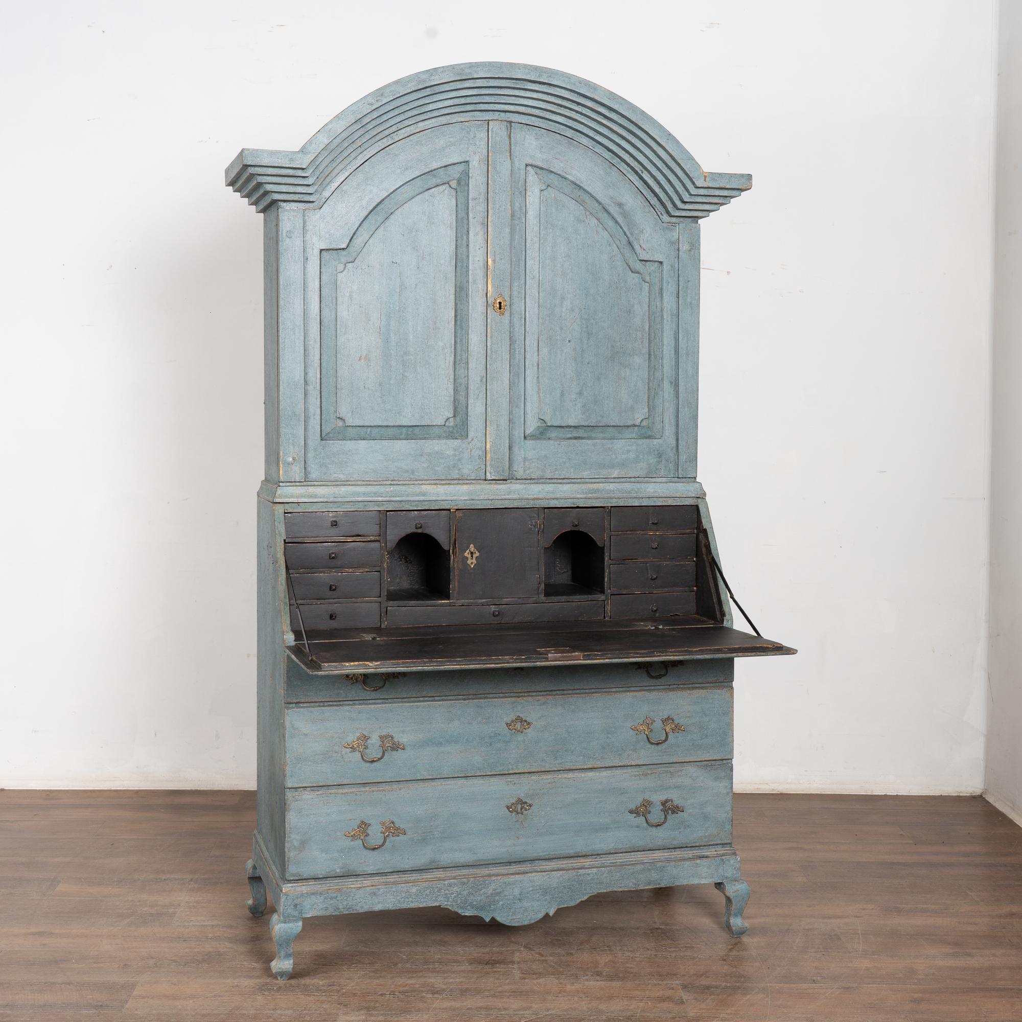This oak secretary is a striking statement piece with panel doors, dramatic bonnet, three large drawers resting on cabriolet feet.
The entire secretary has been given a professional custom layered blue painted finish which has been gently distressed