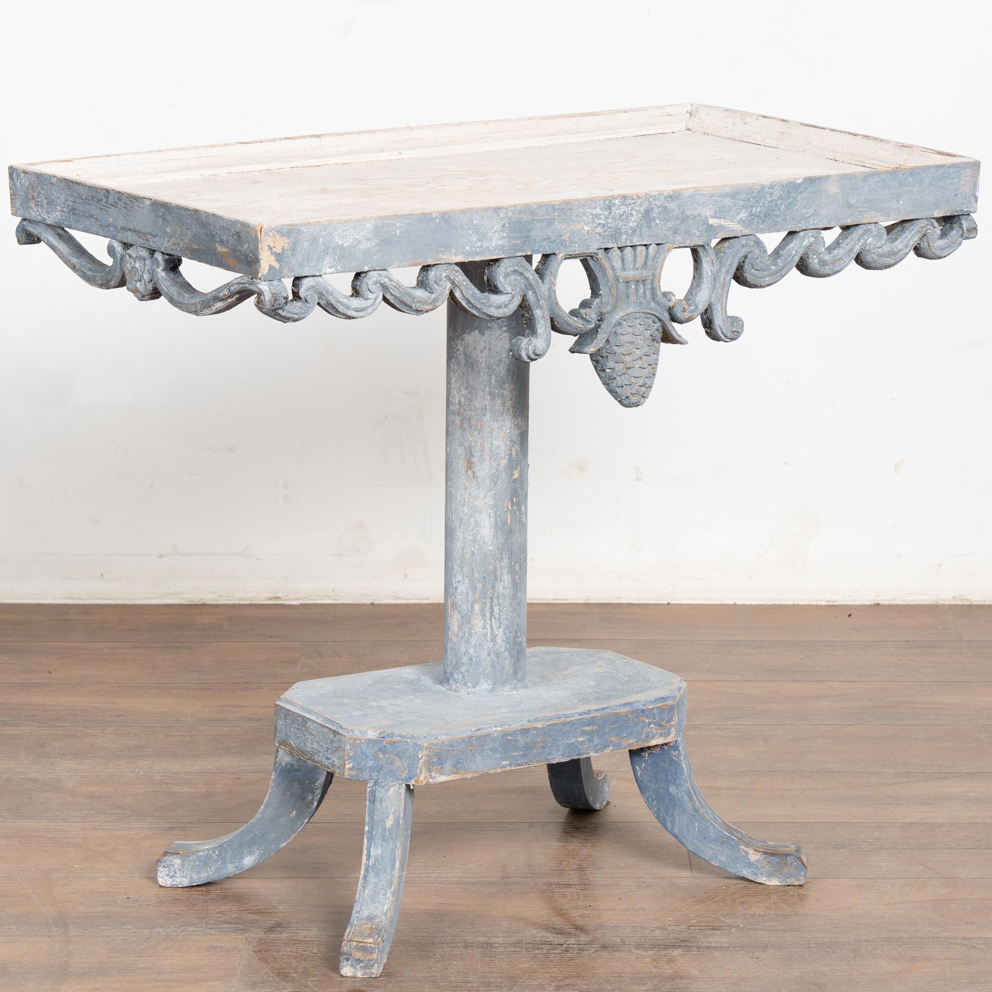 Small pine side table with decorative skirt and pedestal base. 
Restored, later professionally painted in layered shades of blue with white undertones, all lightly distressed to fit the age and grace of this lovely table. Top has contrasting white