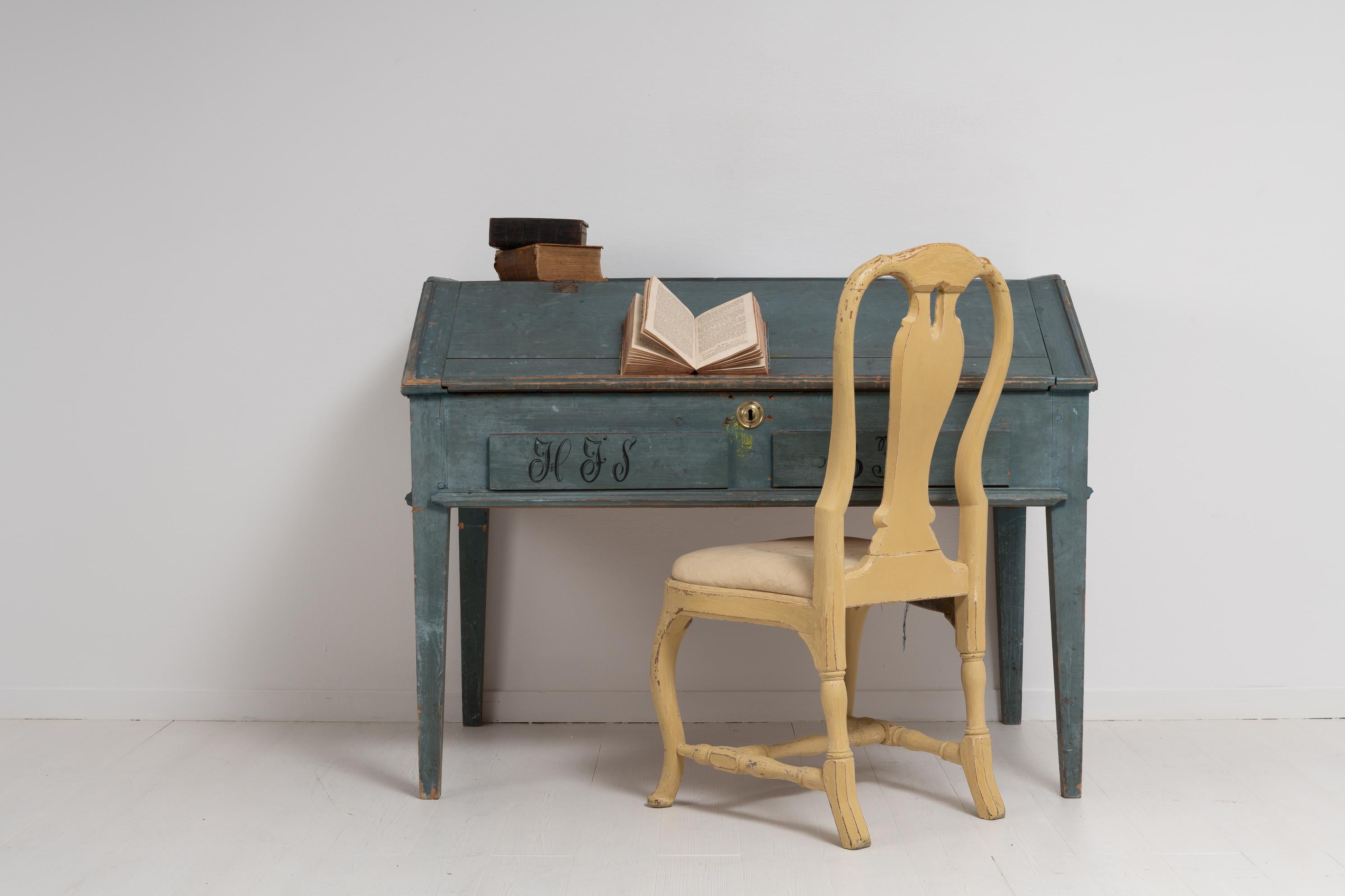Antique genuine pine writing desk from Sweden with blue paint. The table is in untouched original condition with the original blue toned paint. Dated 1850 and monogrammed in black. The desk has an interior with multiple small drawers and shelves.