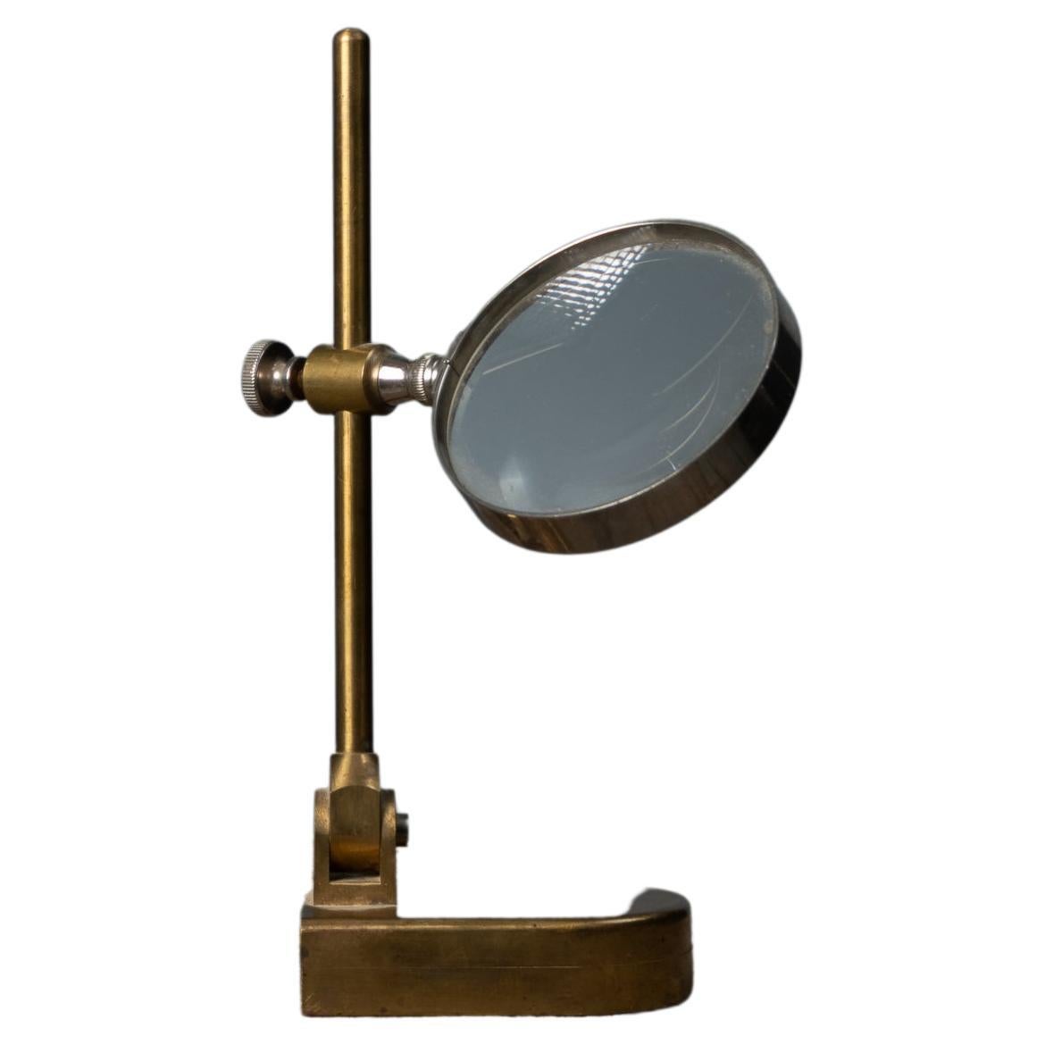 Antique Swedish brass magnifying glass from the second half on the 1800s. The magnifying glass is on a small stand and is ideal for tables or to keep on a decorative shelf. The frame is made in brass and the magnifying glass can be adjusted up and