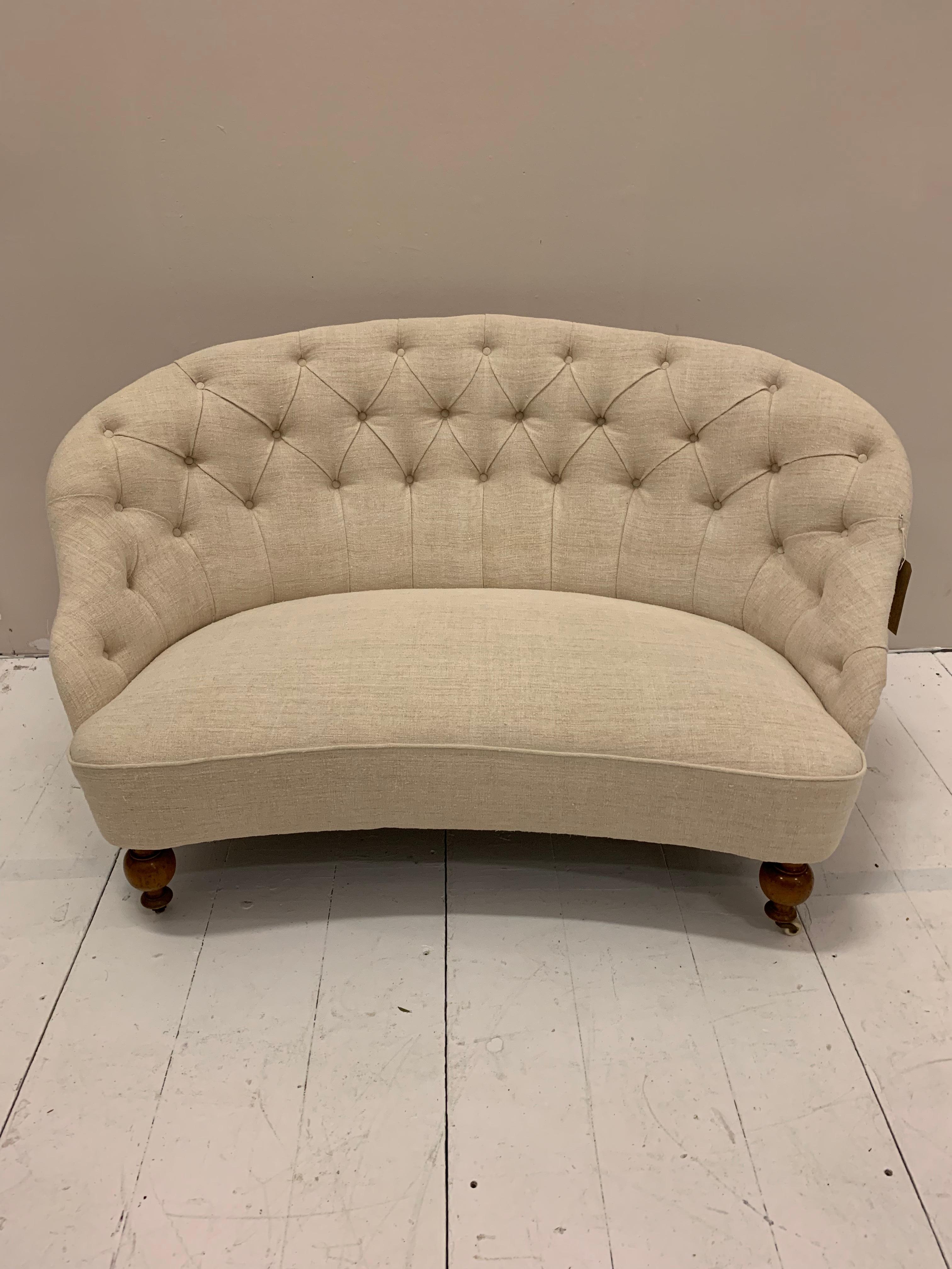 Swedish buttoned back two-seater sofa upholstered in an antique neutral French linen.
This lovely nice quality 19th century iron framed sofa has a rounded back and sits above polished light brown wooden legs on castors.
It would easily work well