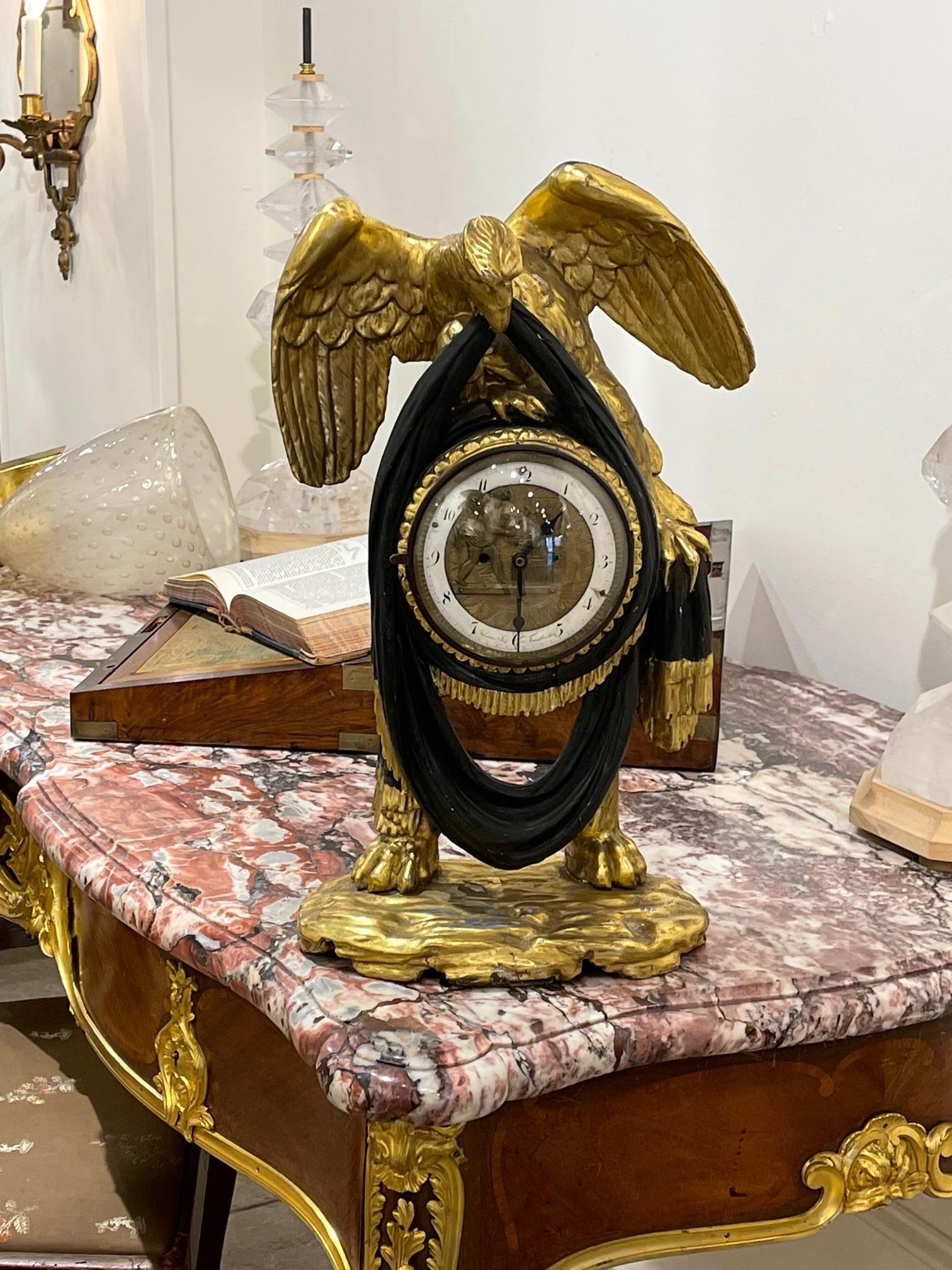 Very fine carved giltwood eagle form mantel clock. Exceptional carving and take notice of the elaborate face of the clock featuring decorative numerals and a cherub. An exceptional piece for your mantel!