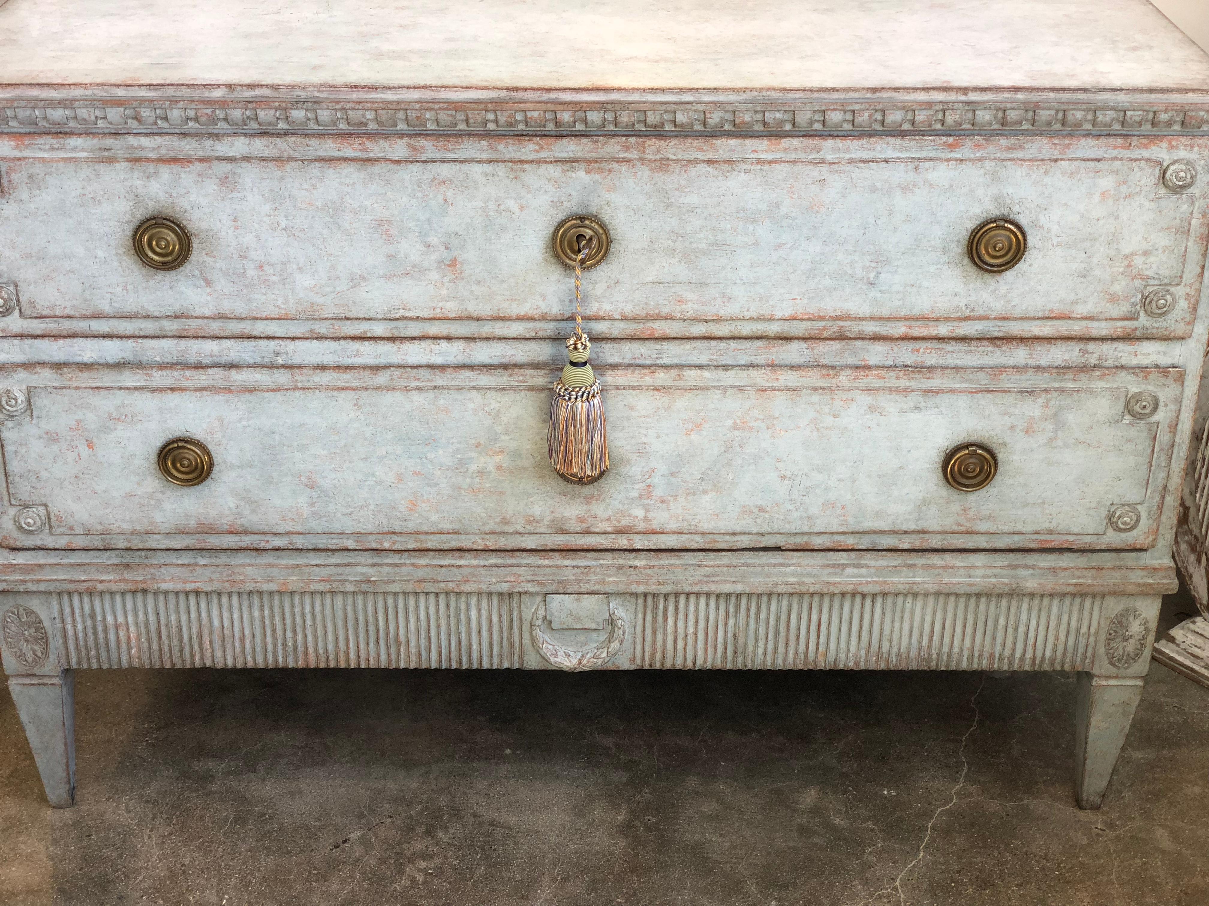 This Swedish Gustavian chest is as pretty as they come! 19th century. Gorgeous pale blue patina color. Sturdy condition with clean hardware. It has pretty dentil detail on top and base has ribbing with a laurel wreath centre relief. Base can be