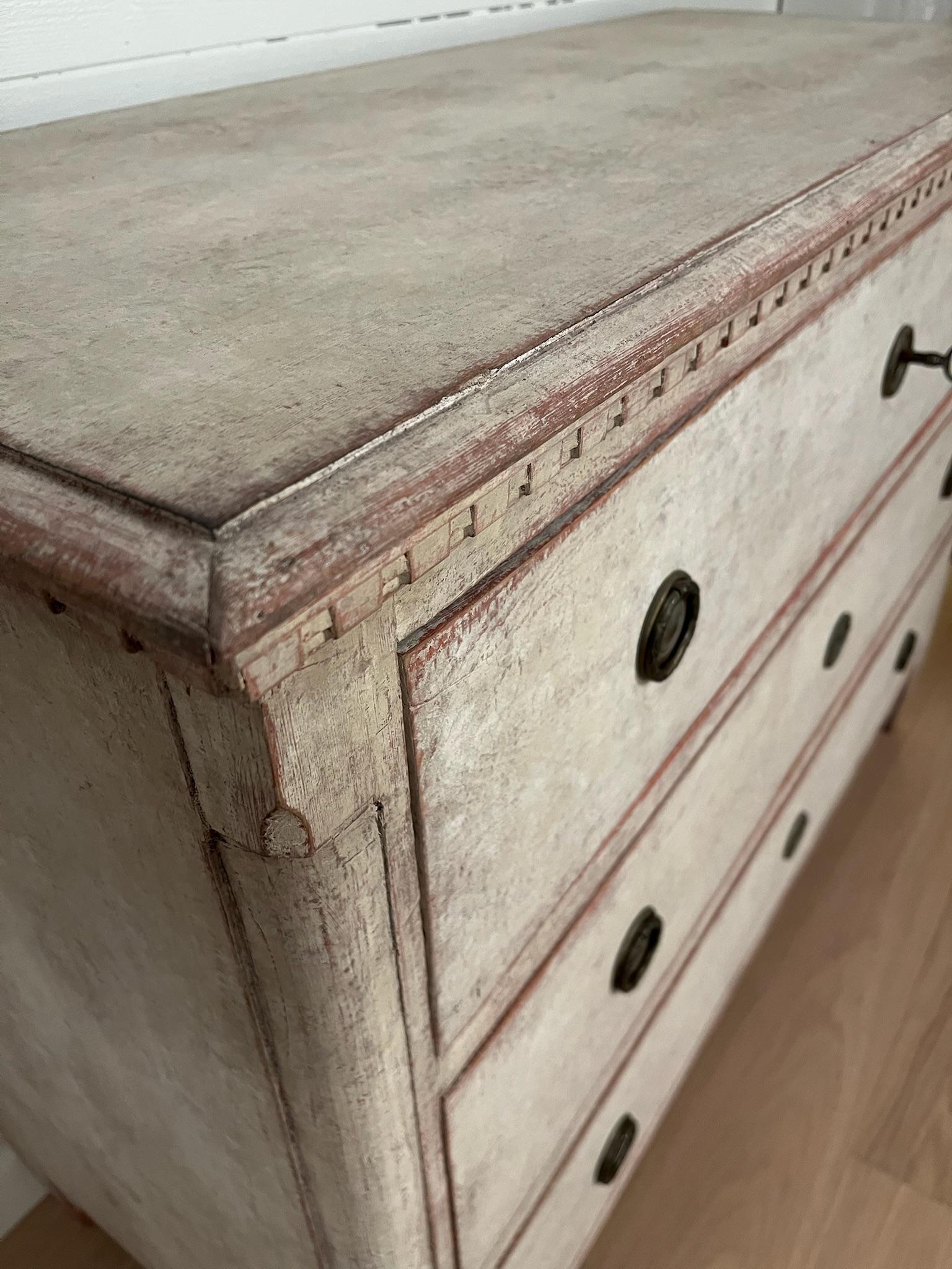 Questa fantastica cassettiera svedese in stile gustaviano è stata realizzata in pino massiccio nel XIX secolo.
dipinto in un grigio tenue con un delicato accenno di rosso e un'angoscia che conferisce un'autentica sensazione di antico.

Il comodino è