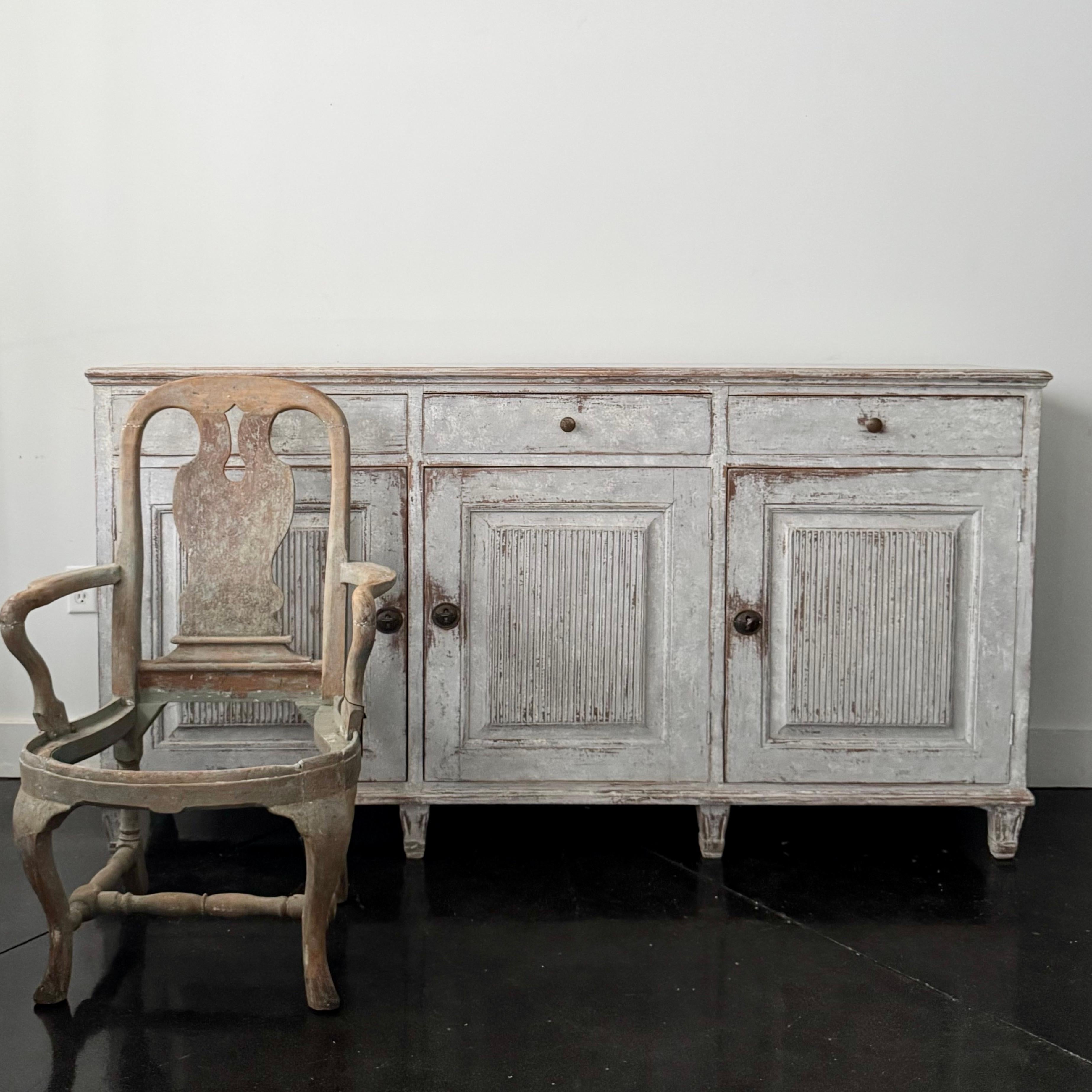 A rare three door Swedish 19th century sideboard in the classic Gustavian Style with carved reeded panel doors and bank of three drawers.
Stockholm, Sweden ca 1840-50