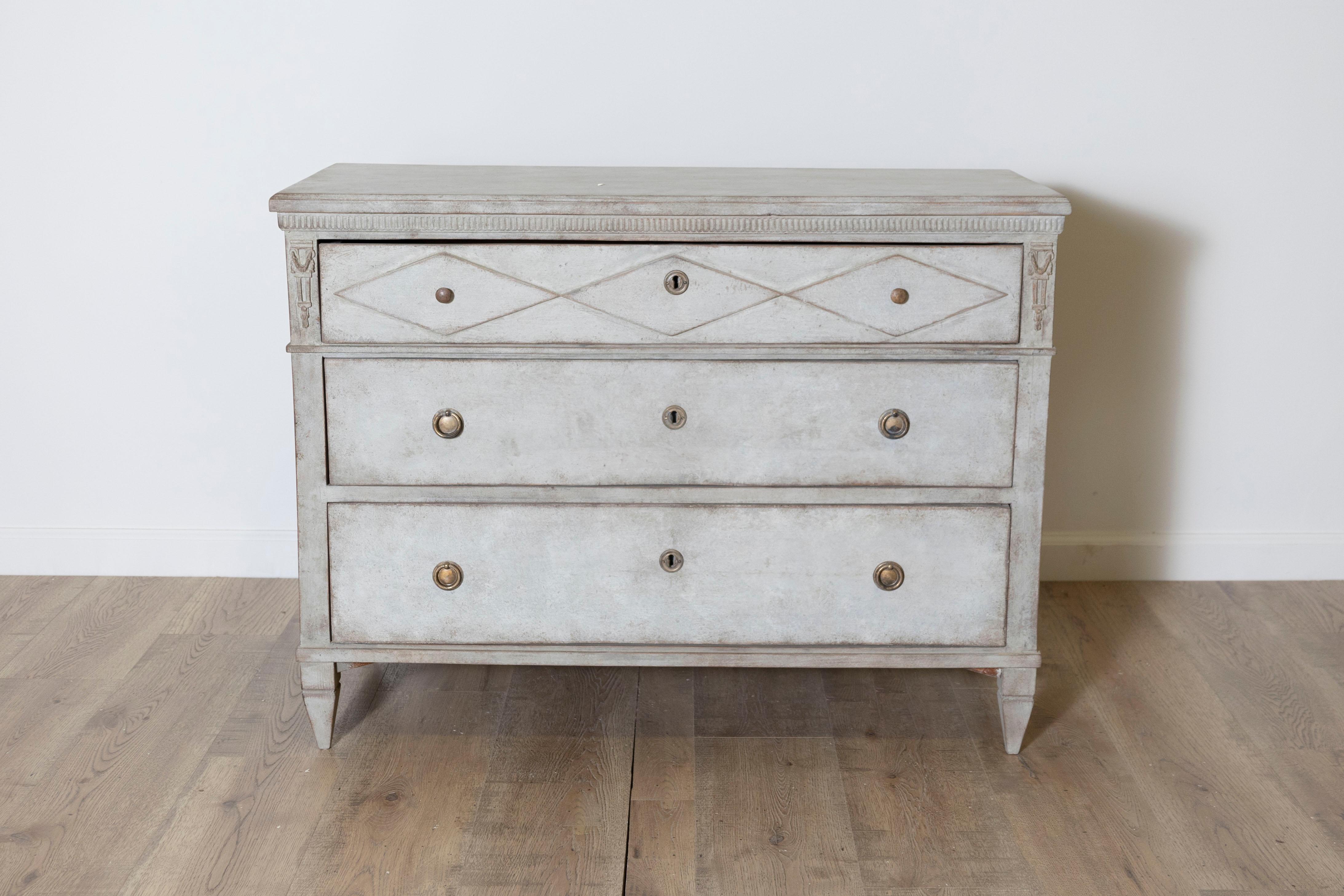 Un bellissimo mobile svedese in stile gustaviano del XIX secolo, circa 1860, dipinto in un grigio tenue con un delicato accenno di verde. Questa elegante cassettiera incarna la raffinatezza understated del design gustaviano, con linee pulite,