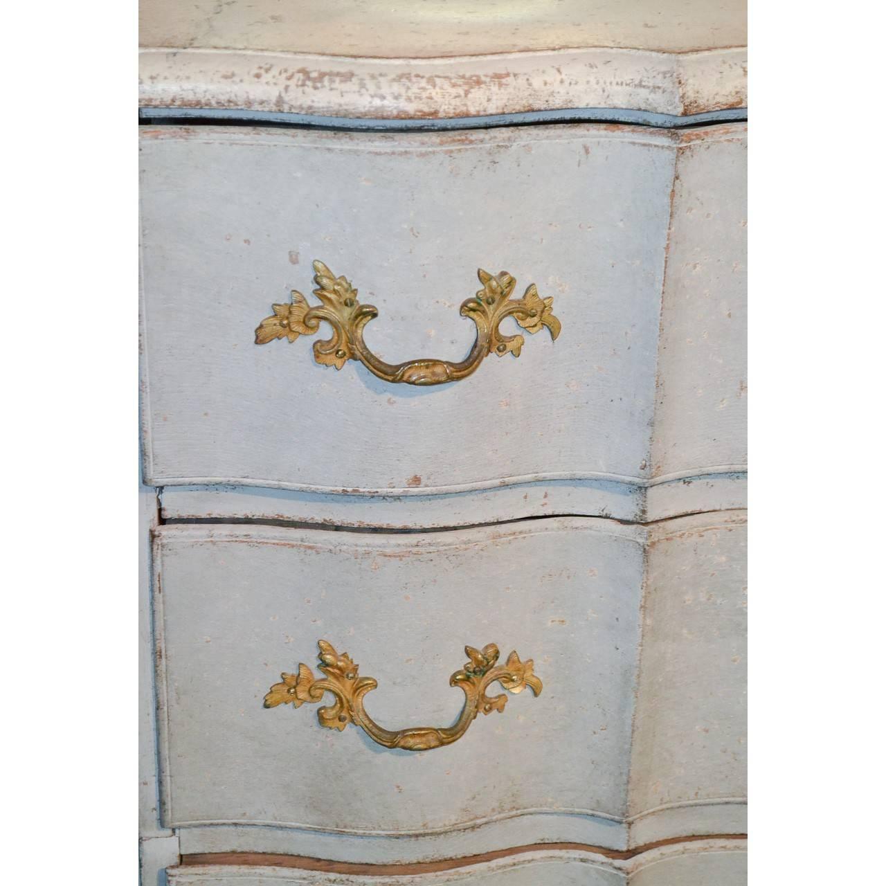 Splendid 19th century Swedish painted shaped front commode with carved corners and inset with four long drawers having fancy bronze pulls and escutcheons. The entire on bun feet.

circa 1850.