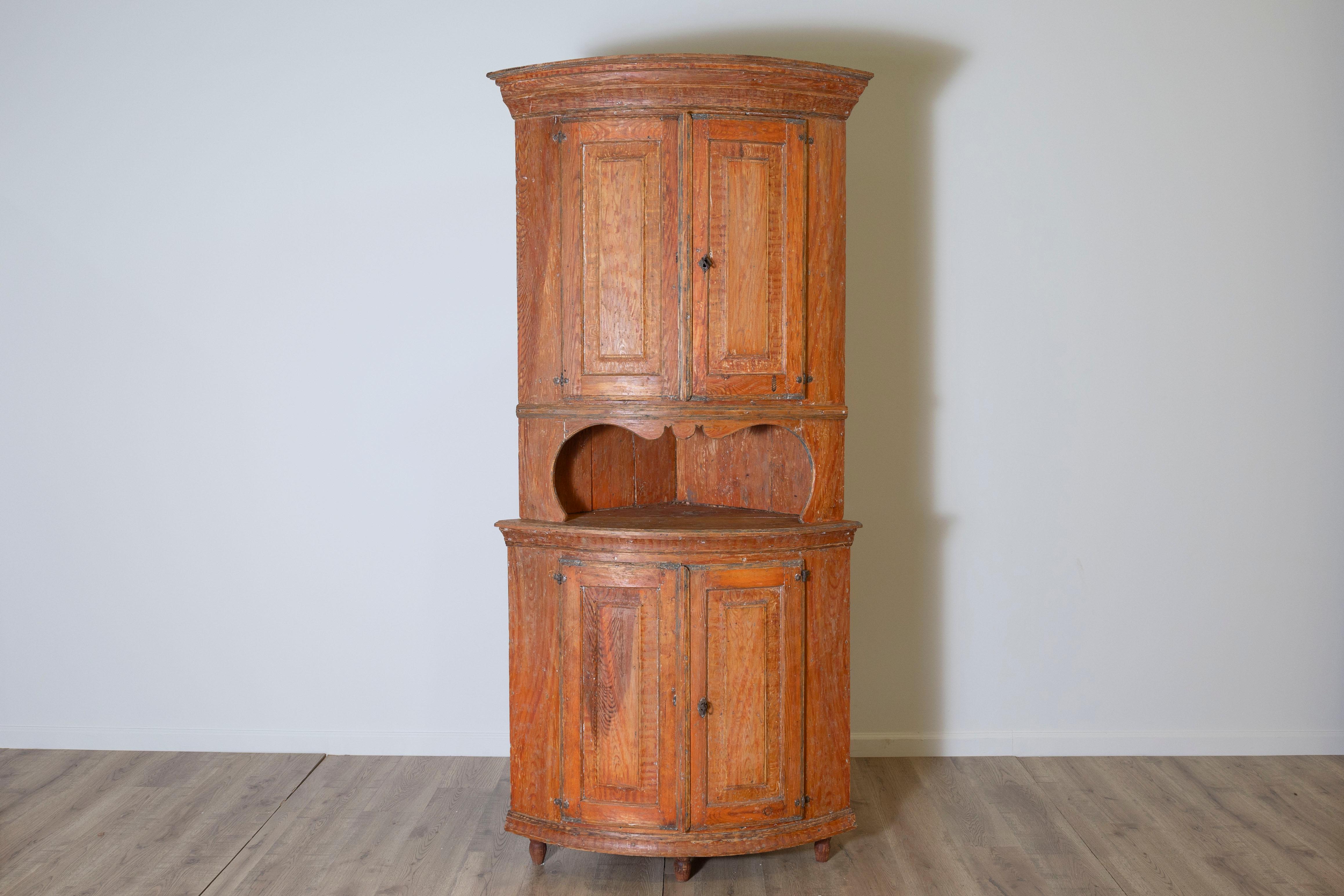 Ce remarquable meuble d'angle suédois du XIXe siècle, datant d'environ 1830, provient de la région de Dalarna, réputée pour sa riche tradition d'artisanat scandinave. Conçue pour s'intégrer parfaitement dans un coin, cette pièce présente une