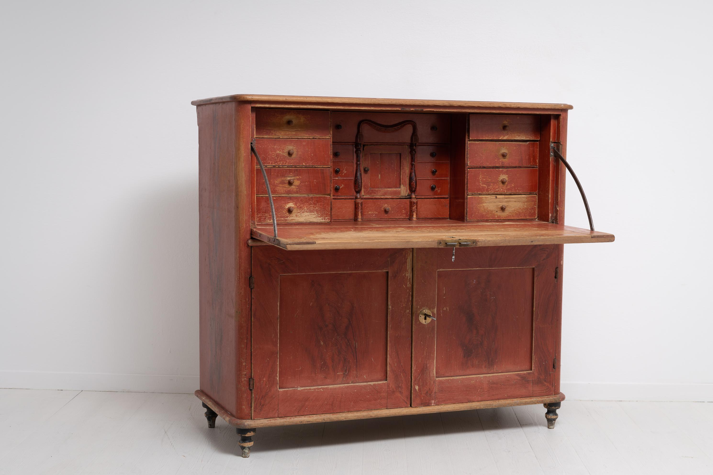 Unusual country secretaire from the empire period Northern Sweden, 1820 to 1840. Painted with the original faux paint and in original condition. The secretaire is made in Swedish pine and has old hardware in brass. The writers desk has an interior