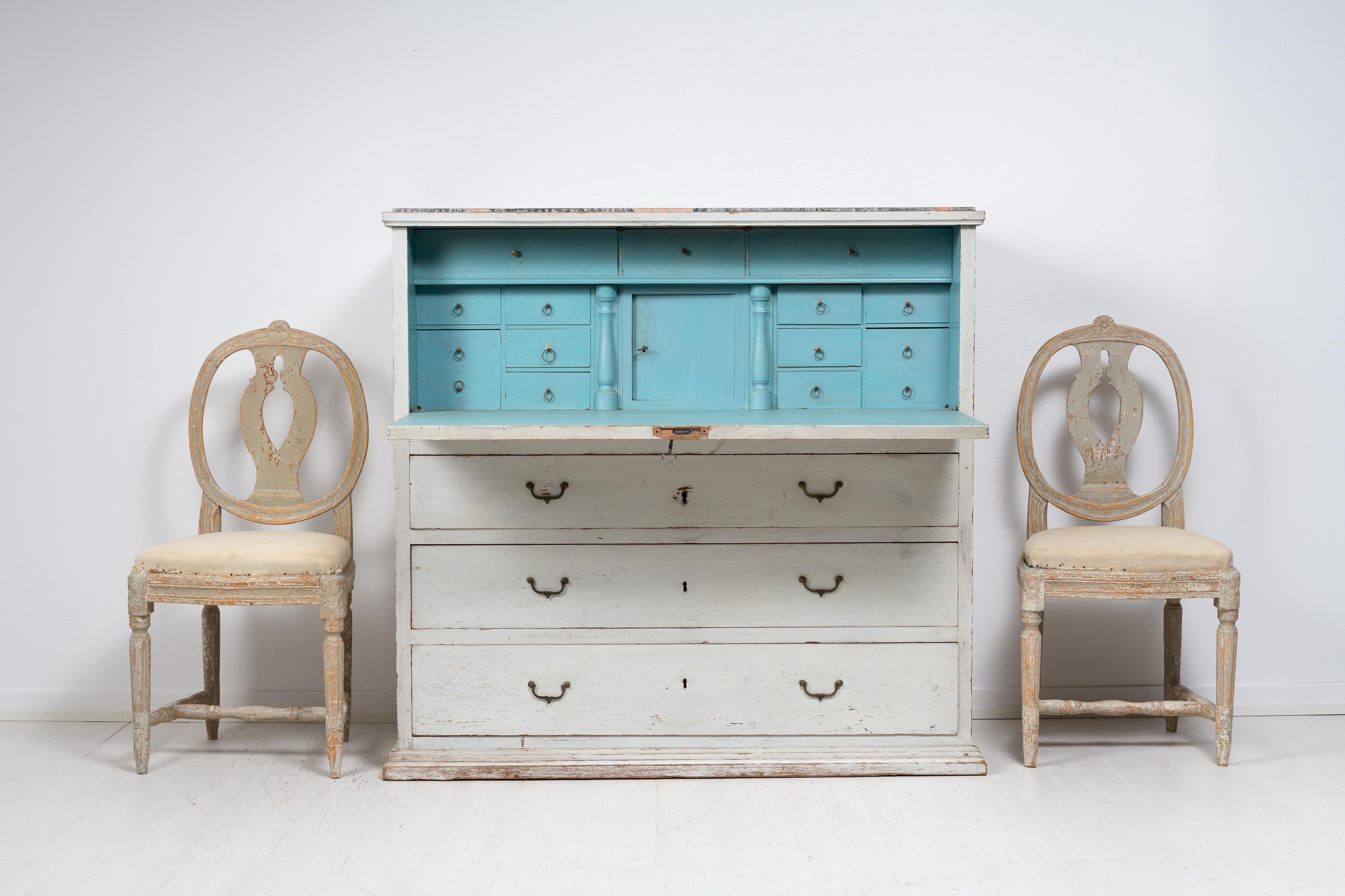 Country home writing bureau in folk art from northern Sweden. The bureau is from around 1820 to 1830 and has a writing desk with interior drawers with brass drawer pulls. Underneath the writing desk are 3 large drawers which are in fully functional