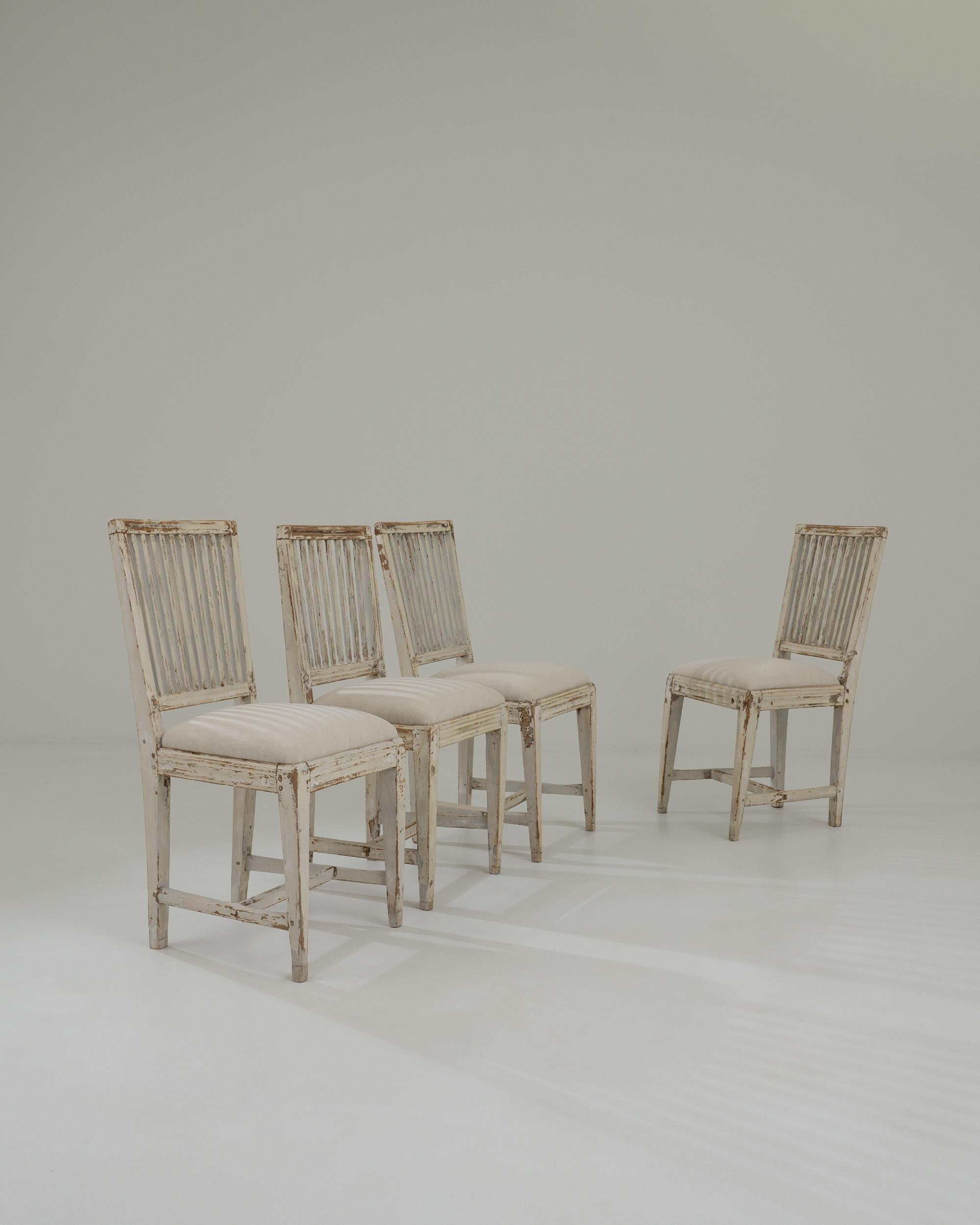 A set of wooden upholstered dining chairs created in 19th century Sweden. Bright and airy, these cheery breathe life into the space, while quietly reminding of their maturity and experience. Created in a classic farmhouse style, each chair gives a