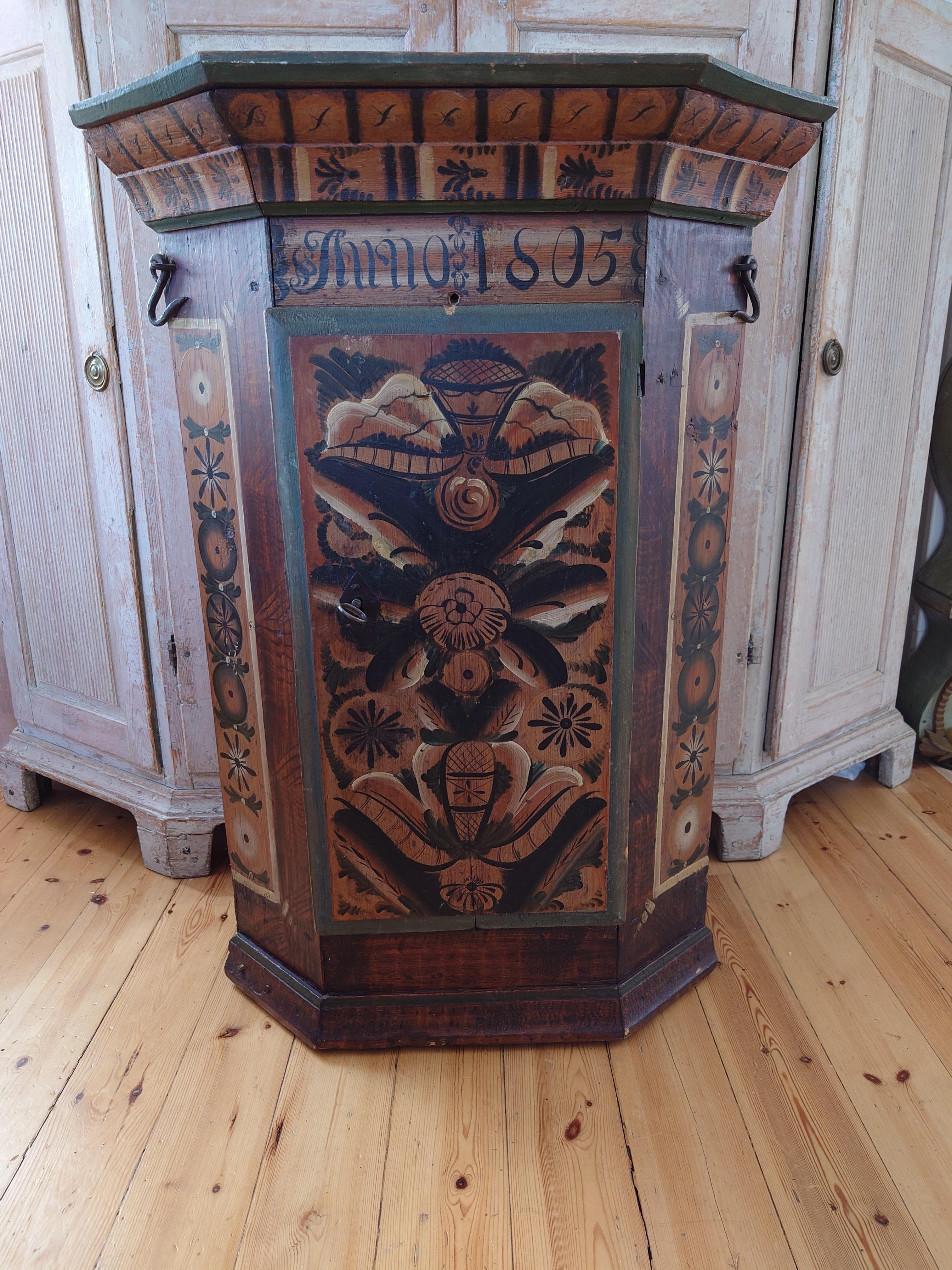 Exceptional 19th century Swedish Dalarna Folk Art Corner Cabinet painted with Kurbits  with center door, Dalarna, Sweden, inscribed and dated: Anno 1805 all original painting.

This corner cabinet, dated 1805, reflects the beautiful, naive painting