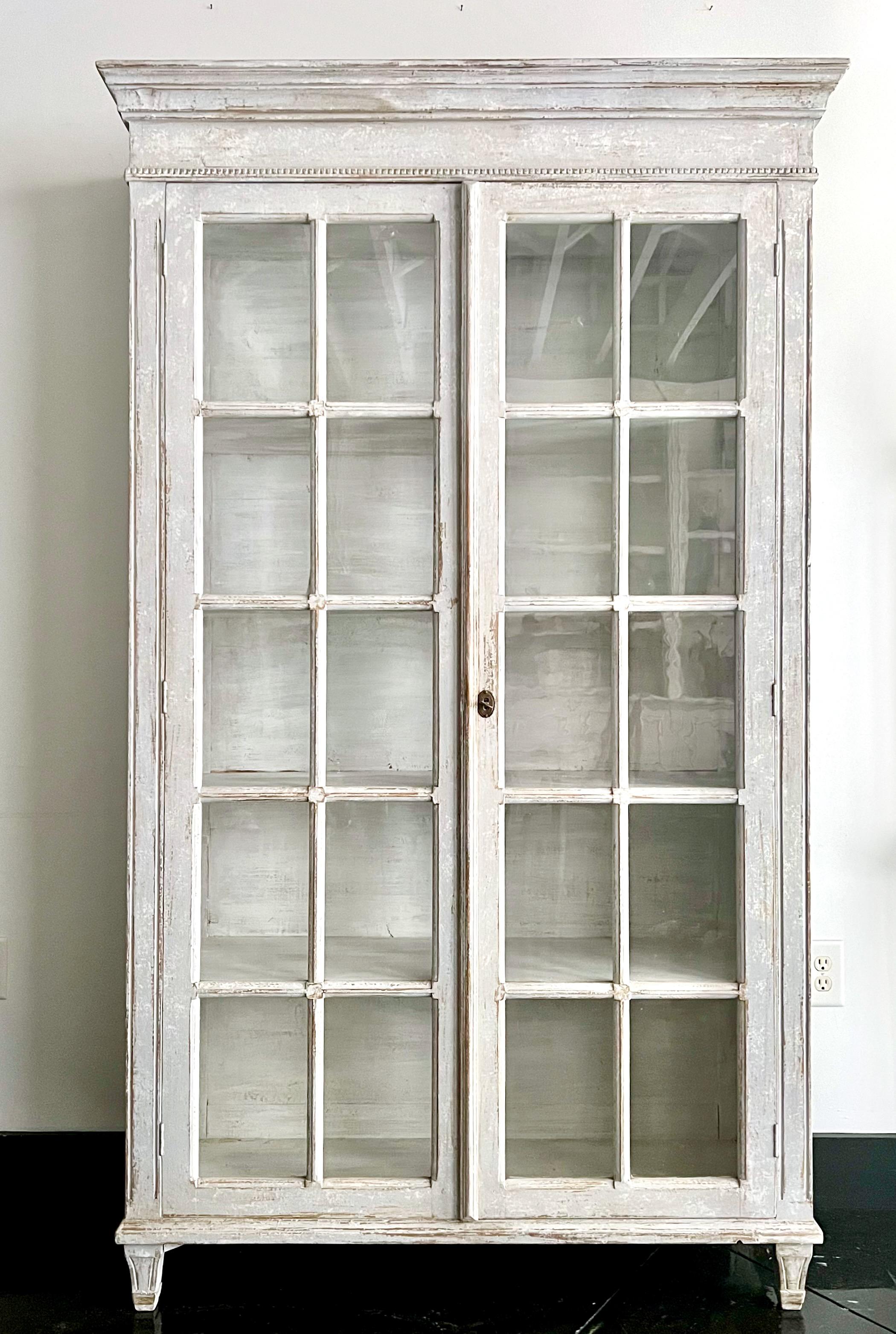 19th century large Swedish painted glazed bookcase/display cabinet 
with double tall doors and glazed panels raised on short tapered carved feet.
Stockholm, Sweden ca. 1880