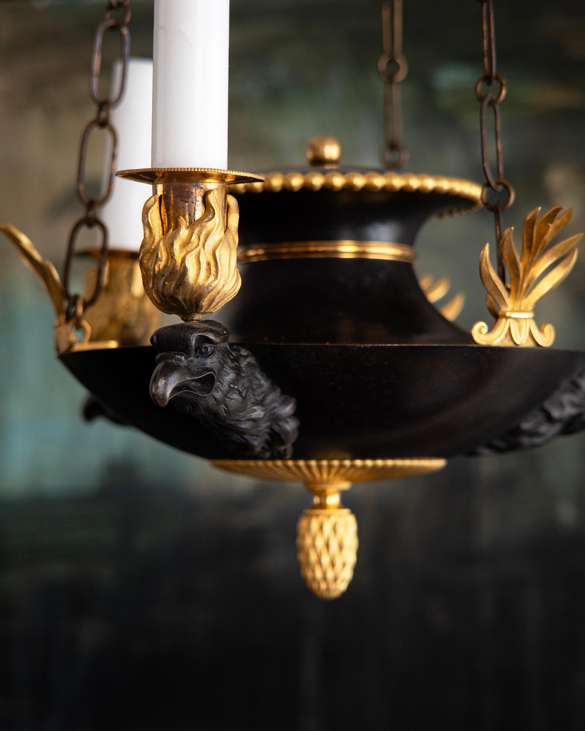 Early 19th century Swedish Empire gilded bronze and patinated iron pendant with three candles resting on Eagle heads. ca 1810 - 1820, Stockholm, Sweden. 