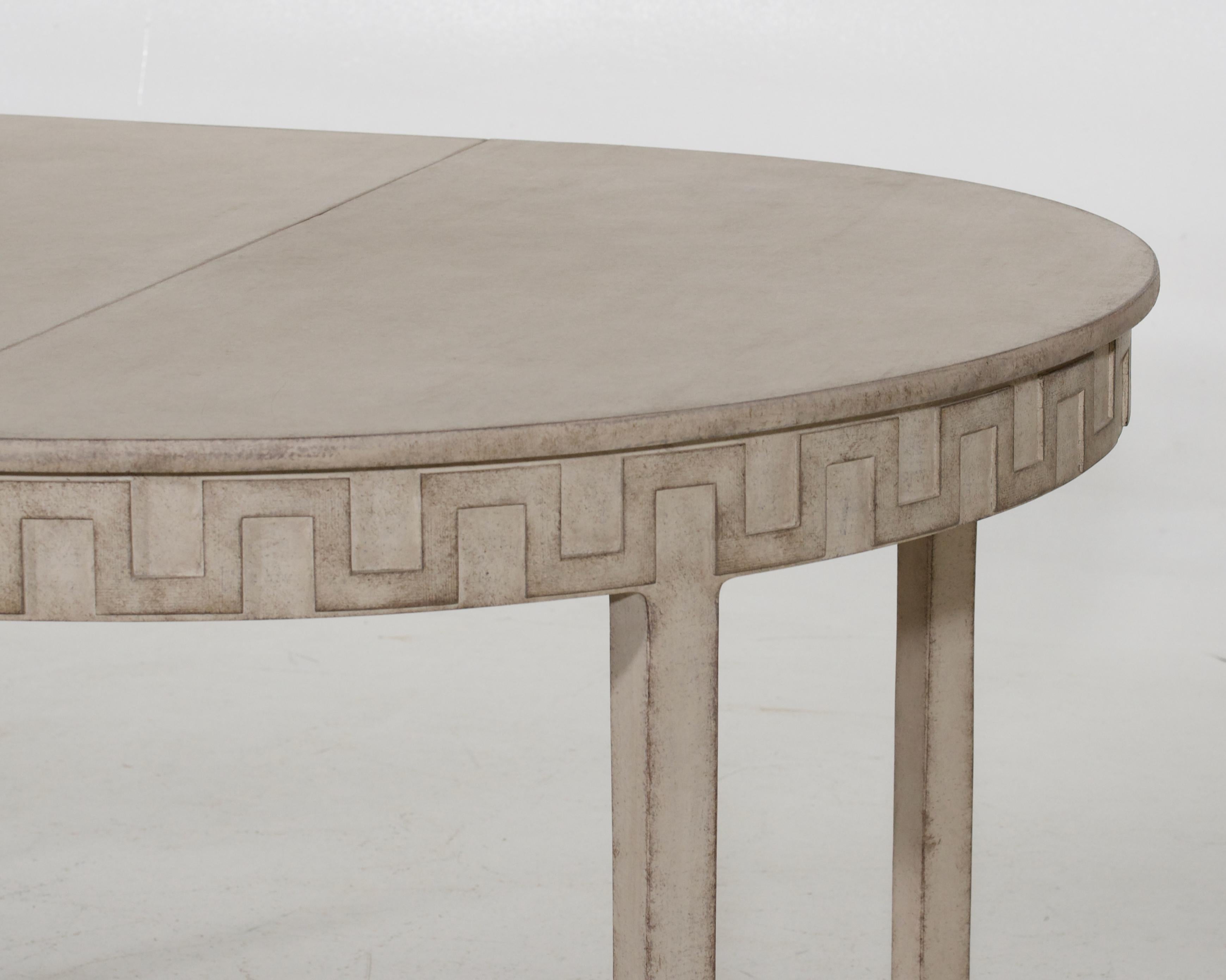 A Swedish extension dining table from the 19th century with carved Greek Key frieze, three leaves and cream / off white painted finish. Discover the epitome of elegance and versatility in this stunning Swedish extension dining table from the 19th