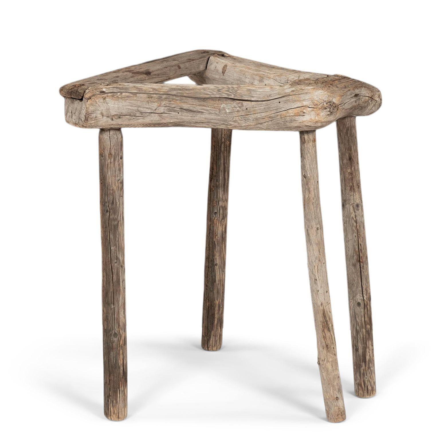 Tabouret de ferme suédois du 19e siècle en bois naturellement blanchi par le soleil et de couleur grise. Ce tabouret de travail était à l'origine utilisé pour de nombreuses tâches, dont la réparation de roues. Forme sculpturale.