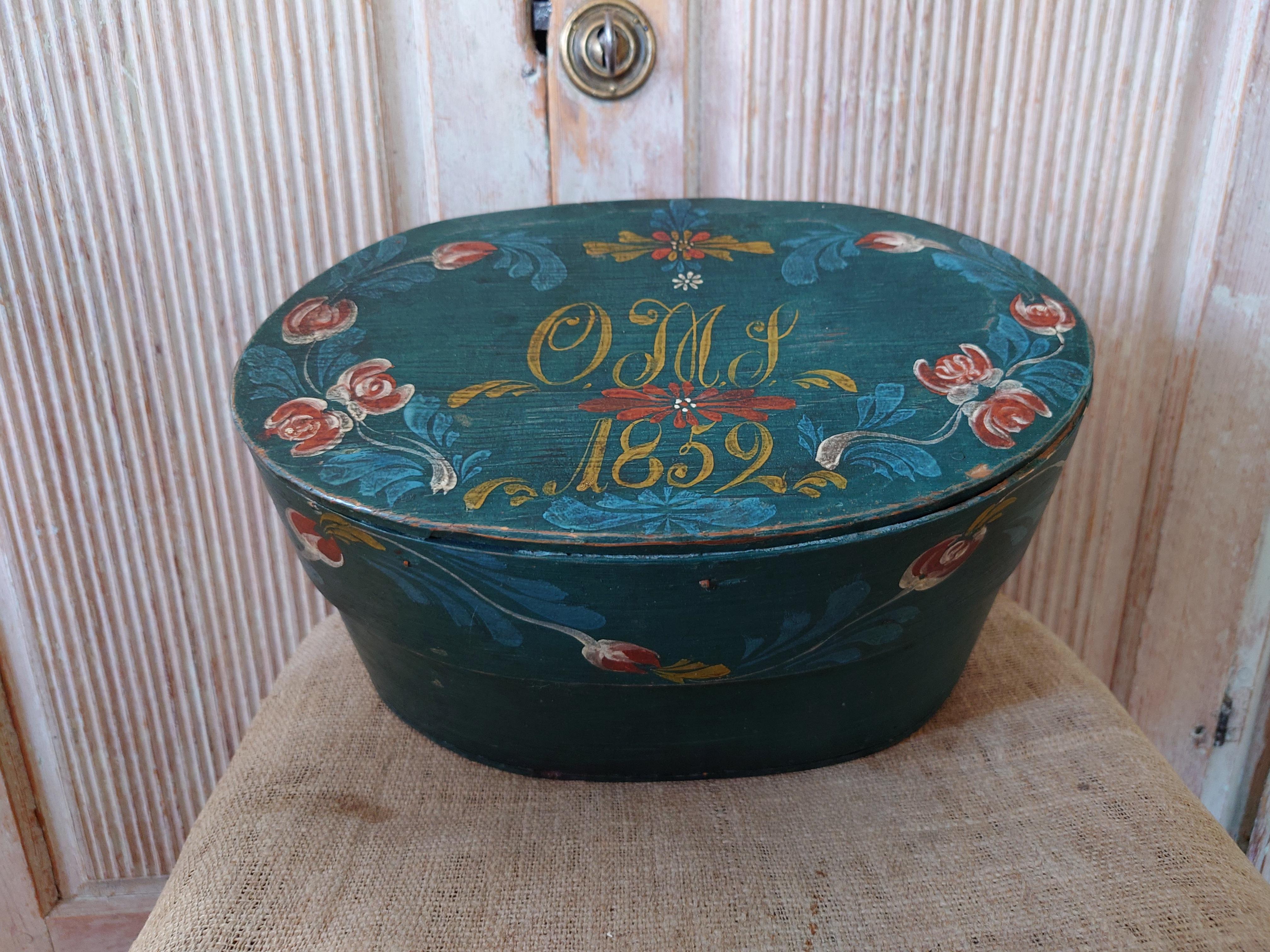 19th Century Swedish Folk Art Bentwood Box from Jämtland ,Northern Sweden.
Oval box with lid.
Untouched originalpaint with beautiful painted flowers .Dated 1859 and Owner initials OMS. It has a hand cut heart at the box.

Valuables were stored in