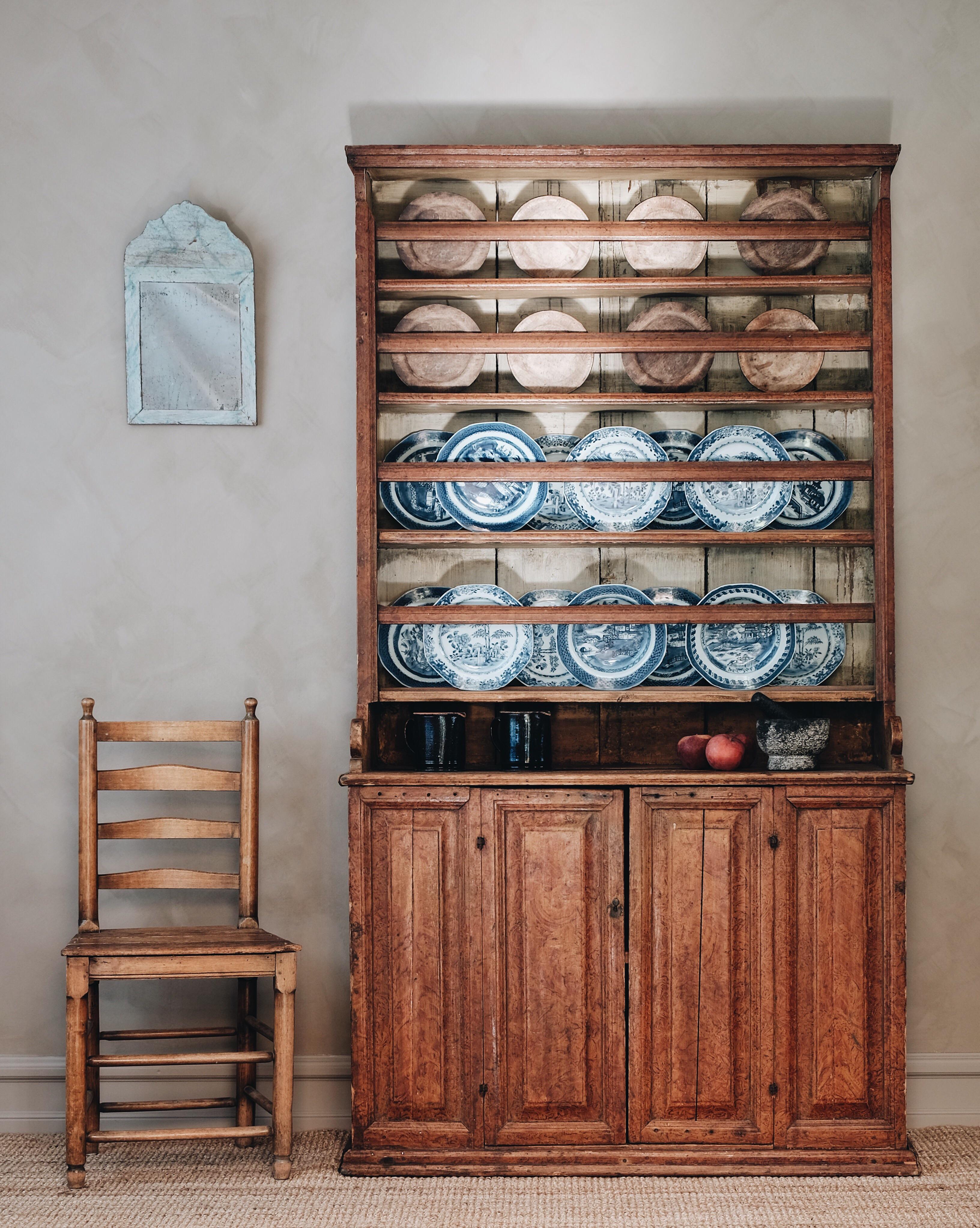 Delightful 19th century Swedish Folk Art dresser in its original faux wood painted finish with a great patinated surface. The dresser has four plate racks and two cupboard doors containing one shelf, circa 1810.

Good condition with wear