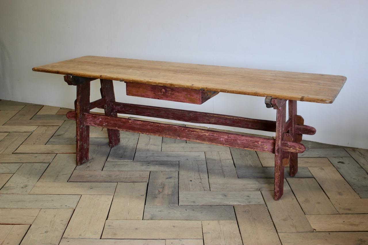 A very charming and retaining the original paint, 19th century Swedish folk art trestle table in pine, that will seat eight to 10 people. The table with a single central drawer. Lovely and original colour.