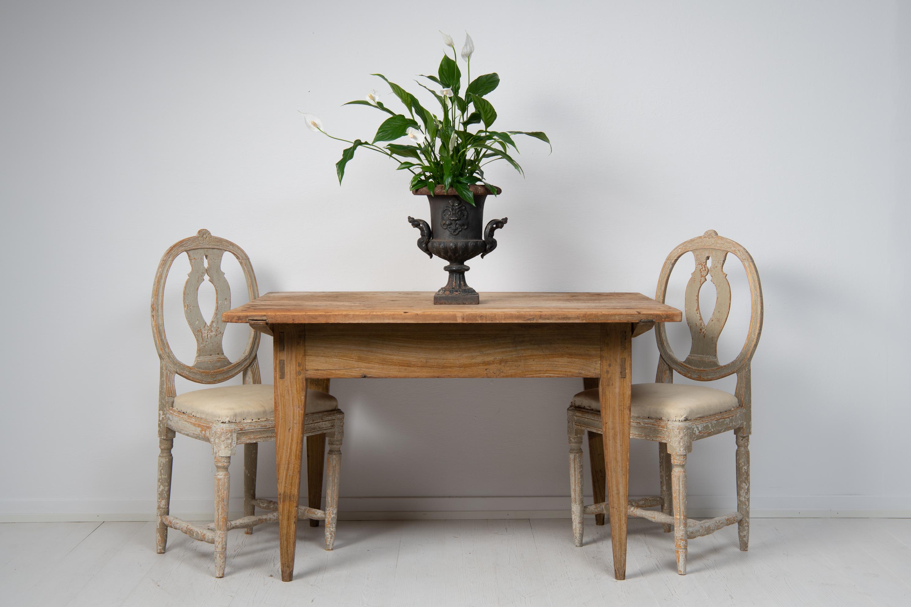 Swedish work or dining table in folk art from the early 19th century, around 1820. The table is a Swedish antique, genuine and honest with a solid frame and simple design. The proportions are charming with a slightly oversized table top and stable