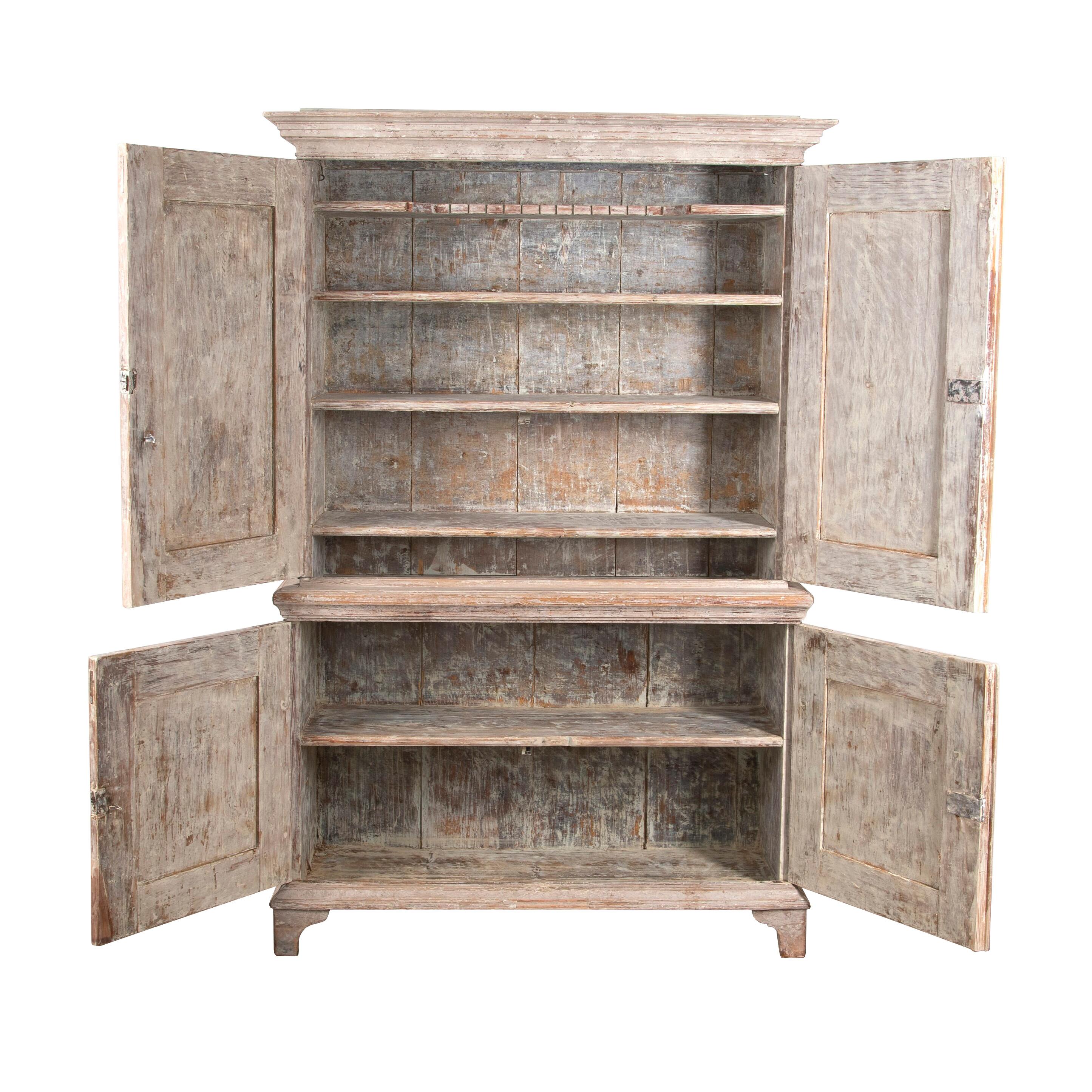 19th century Swedish two-part cabinet.
With a carved pediment and two doors with a decorative reeded design that open to useful storage.
Below are two further doors with the same design opening to further storage.
This piece has been repainted.