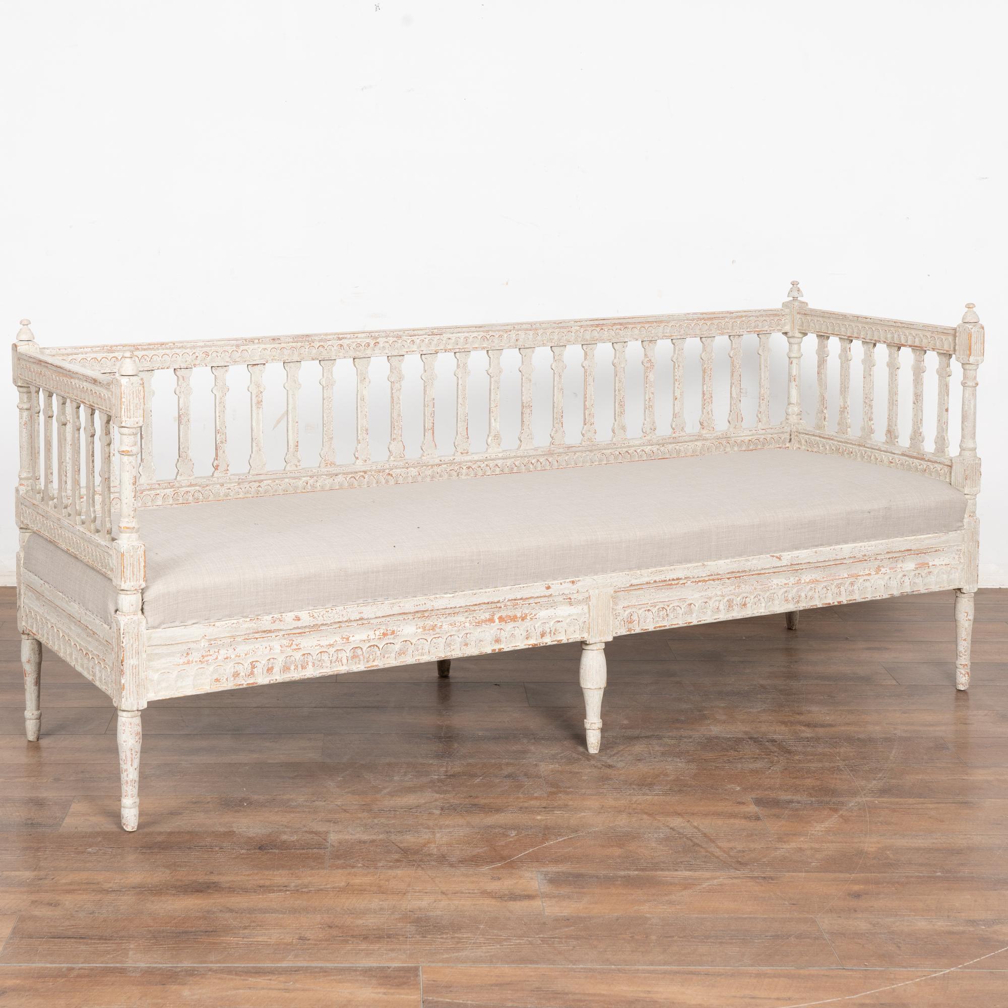 This lovely bench is a wonderful example of Swedish Gustavian craftsmanship with turned finials and feet, slat back and egg and dart carving adding to its timeless appeal.
The gray painted finish (with white undertones) has been scraped revealing