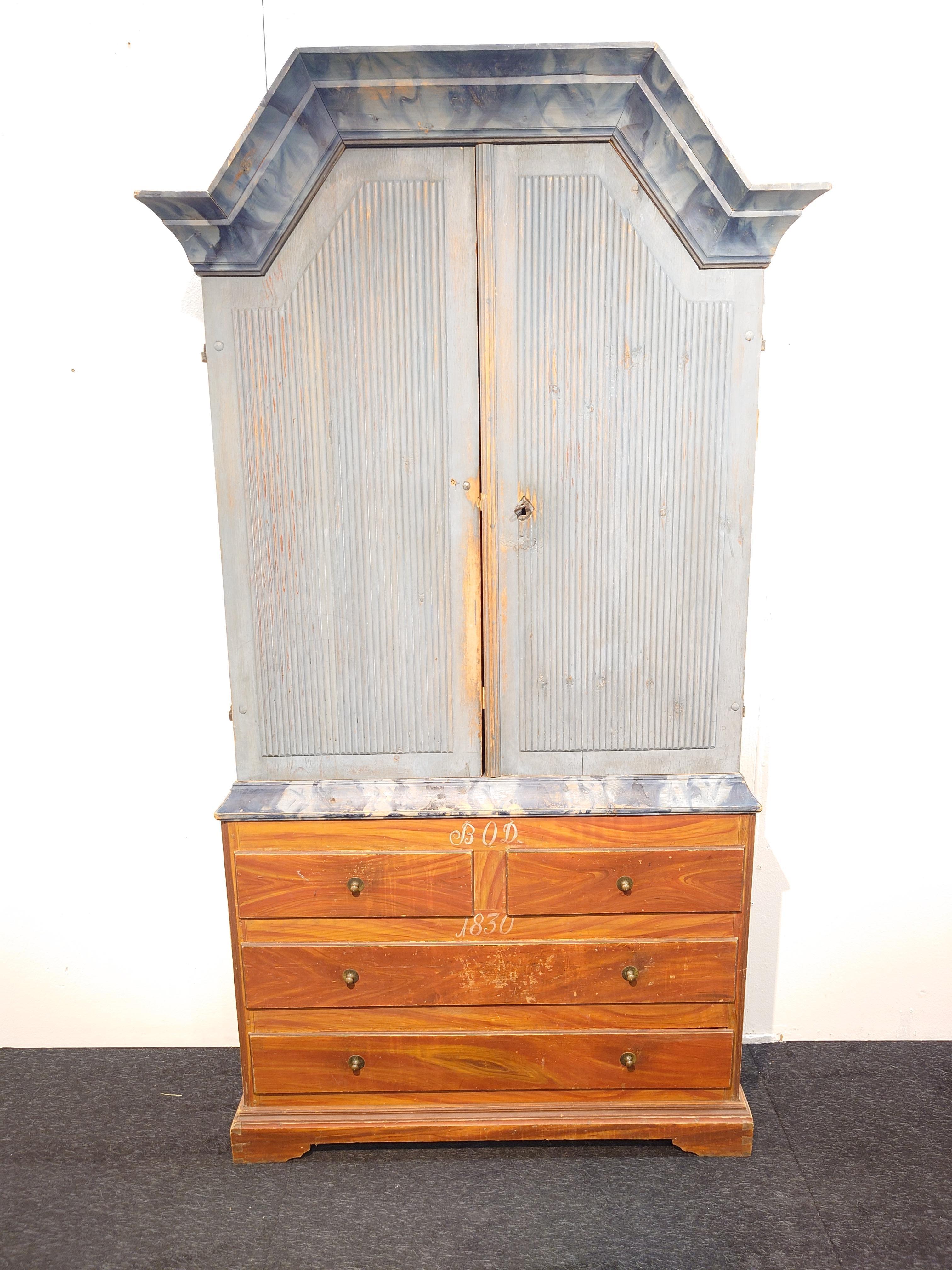 19th Century Swedish antique Jämtskåp from Jämtland .The beautifully marbled crown in the lovely blue shade.The upper cabinet has reeded doors, and the lower part with the imitation of precious wood, monogrammed BOD and dated 1830. The interior is