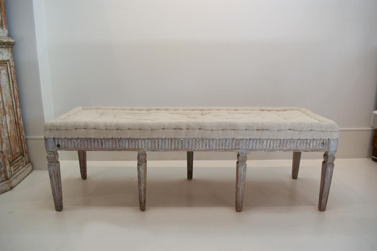 This elegant 19th Century Swedish Gustavian long bench epitomizes the refined simplicity and timeless charm of Gustavian design. Crafted from high-quality wood, the bench features clean lines and understated detailing that are hallmarks of the