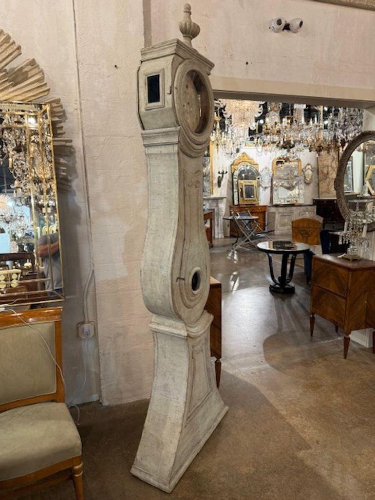 Este producto es un reloj de pie pintado de estilo Gustaviano sueco del siglo XIX. Se trata de una pieza de decoración elegante y con estilo que destacará en cualquier habitación. El intrincado diseño y la artesanía de este reloj lo convierten en un